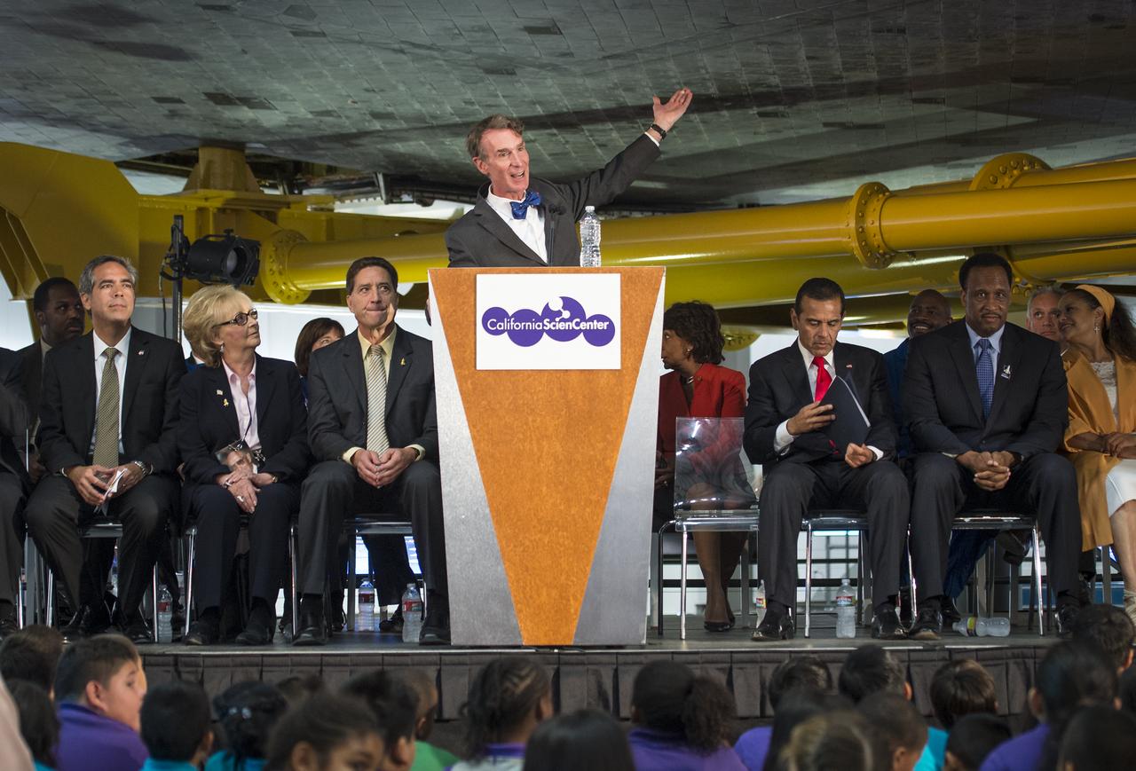 Chief Executive Officer of the Planetary Society, Bill Nye "The Science Guy", acts as emcee from a podium underneath the space shuttle Endeavour during the grand opening ceremony for the center's Samuel Oschin Space Shuttle Endeavour Display Pavilion, Tuesday, Oct. 30, 2012, in Los Angeles.  Endeavour, built as a replacement for space shuttle Challenger, completed 25 missions, spent 299 days in orbit, and orbited Earth 4,671 times while traveling 122,883,151 miles. Photo Credit: (NASA/Bill Ingalls)