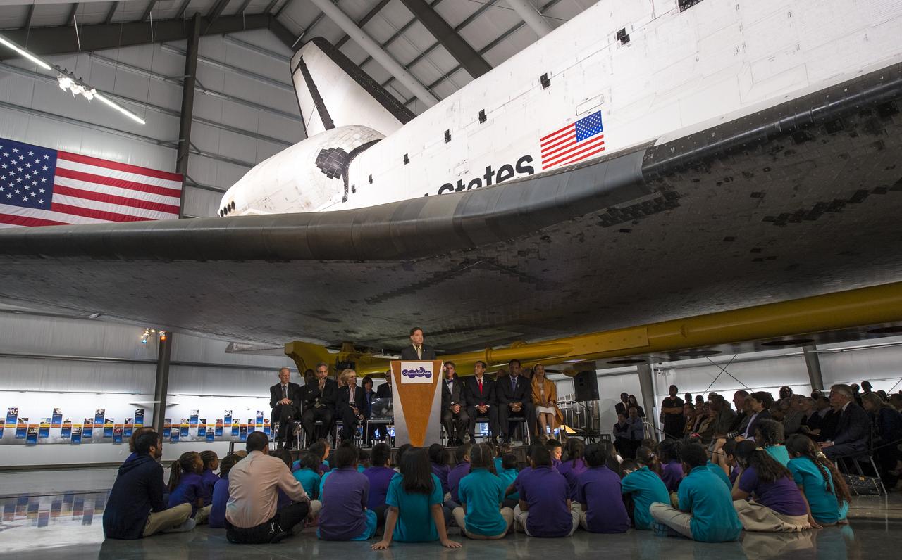 President and CEO of the California Science Center Jeffrey N. Rudolph speaks from a podium underneath the space shuttle Endeavour during the grand opening ceremony for the center's Samuel Oschin Space Shuttle Endeavour Display Pavilion, Tuesday, Oct. 30, 2012, in Los Angeles.  Endeavour, built as a replacement for space shuttle Challenger, completed 25 missions, spent 299 days in orbit, and orbited Earth 4,671 times while traveling 122,883,151 miles. Photo Credit: (NASA/Bill Ingalls)