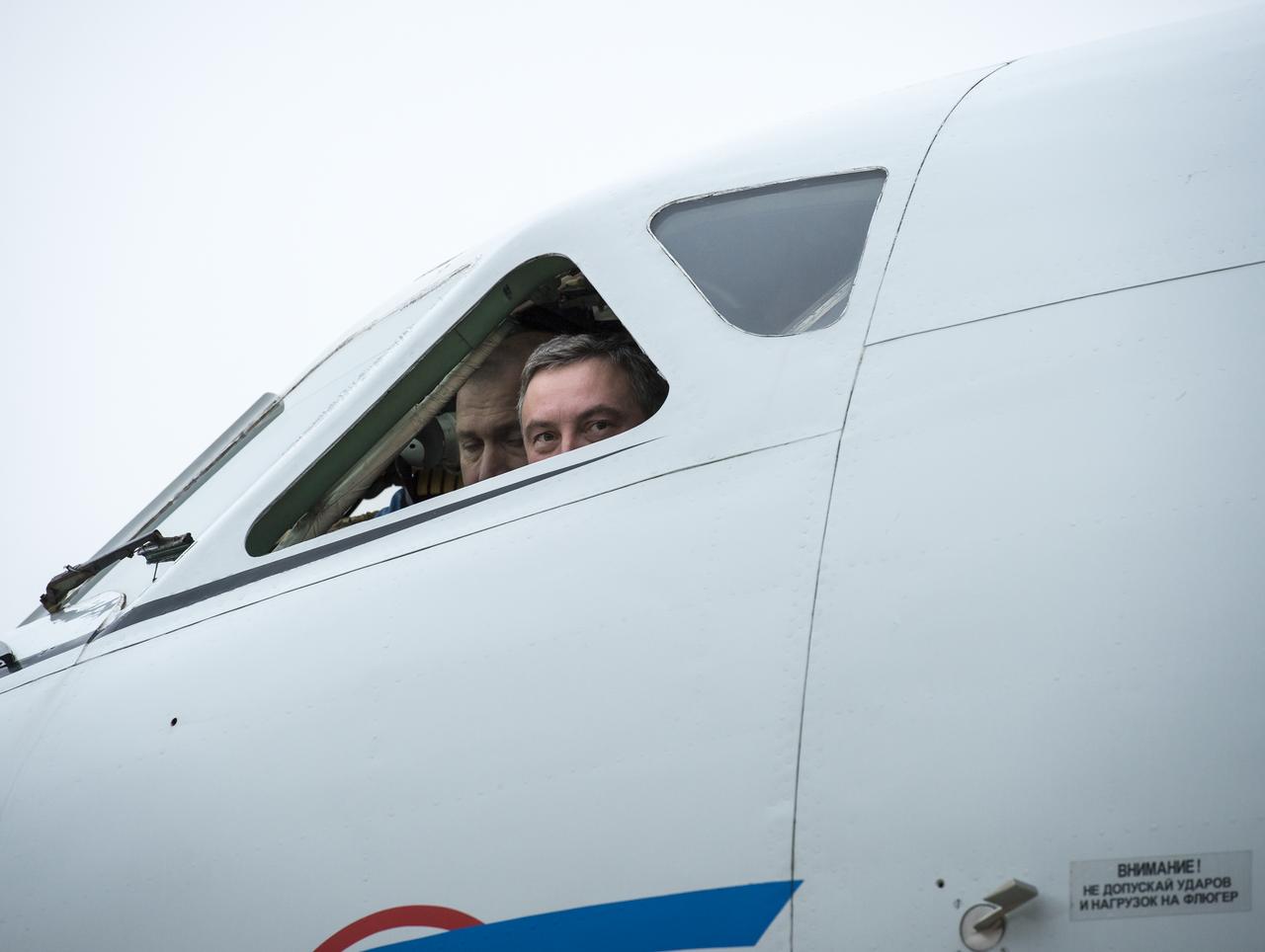 Pilots look out from the cockpit and watch as Expedition 33 Flight Engineer Yuri Malenchenko of ROSCOSMOS (Russian Federal Space Agency) is welcomed home at the Chkalovsky Airport in Star City, Russia by officials and his family after he, Commander Sunita Williams of NASA, and Flight Engineer Akihiko Hoshide of JAXA (Japan Aerospace Exploration Agency), landed their Soyuz spacecraft in a remote area outside the town of Arkalyk, Kazakhstan, on Monday, Nov. 19, 2012. Williams, Hoshide and Malenchenko returned from four months onboard the International Space Station. Photo Credit: (NASA/Bill Ingalls)
