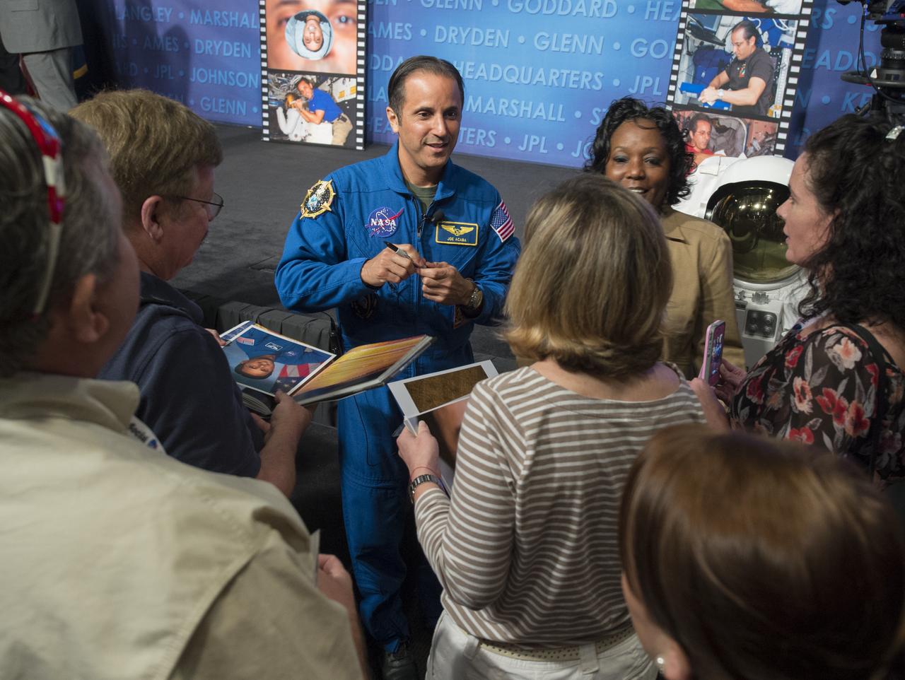 NASA astronaut Joe Acaba, center, greets participants at a behind-the-scenes NASA Social in Washington, Tuesday, Dec. 4, 2012 at NASA Headquarters. Acaba launched to the International Space Station on a Russian Soyuz spacecraft May 15, 2012, spending 123 days aboard as a flight engineer of the Expedition 31 and 32 crews. He recently returned to Earth on Sept. 17 after four months in low earth orbit. Photo Credit: (NASA/Carla Cioffi)