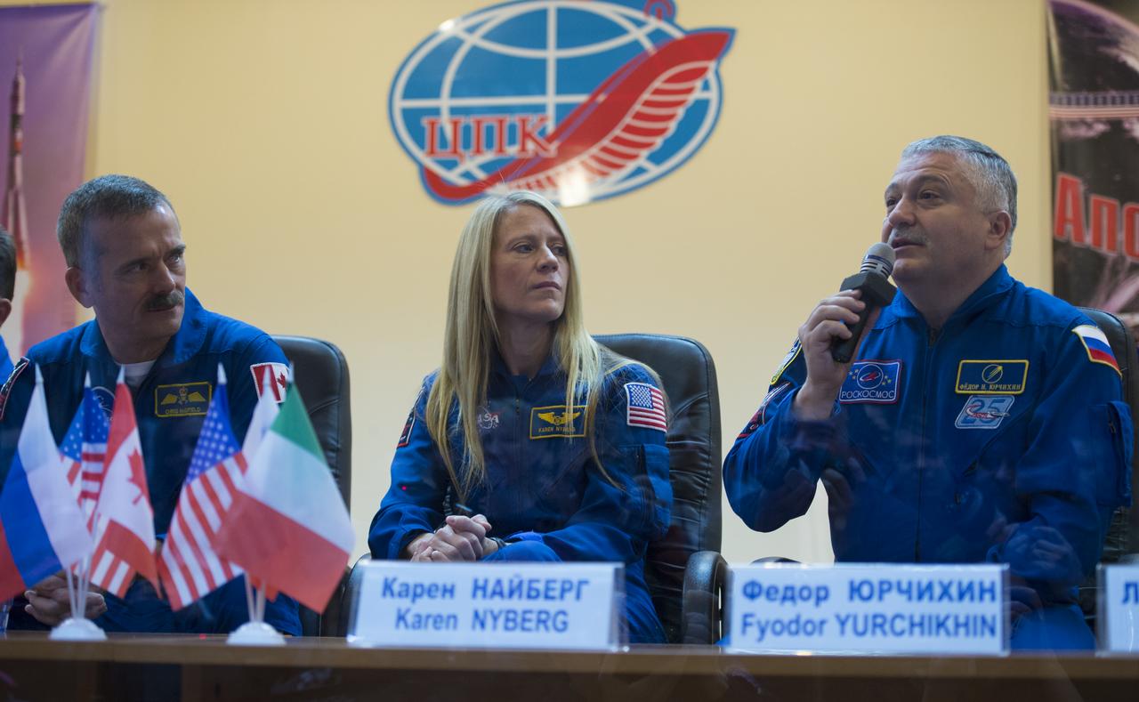 Russian backup crew member Fyodor Yurchikin, right, answers a reporter's question at a press conference held at the Cosmonaut Hotel, on Tuesday, Dec. 18, 2012, in Baikonur, Kazakhstan. Seen next to him are NASA backup crew member Karen Nyberg and Expedition 34/35 Canadian Space Agency astronaut Chris Hadfield. Photo Credit: (NASA/Carla Cioffi)