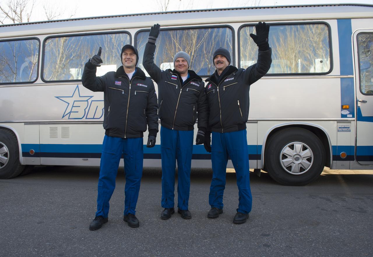 Expedition 34/35 crew members, Flight Engineer Tom Marshburn of NASA, left, Soyuz Commander Roman Romanenko of ROSCOSMOS, and Flight Engineer Chris Hadfield of the Canadian Space Agency (CSA), right, wave farewell to family and friends as they depart the Cosmonaut Hotel to suit-up for their soyuz launch to the International Space Station on Wednesday, Dec. 19, 2012, in Baikonur, Kazakhstan. Launch of the Soyuz rocket will send Hadfield, Romanenko and Marshburn on a five-month mission aboard the International Space Station. Photo Credit: (NASA/Carla Cioffi)