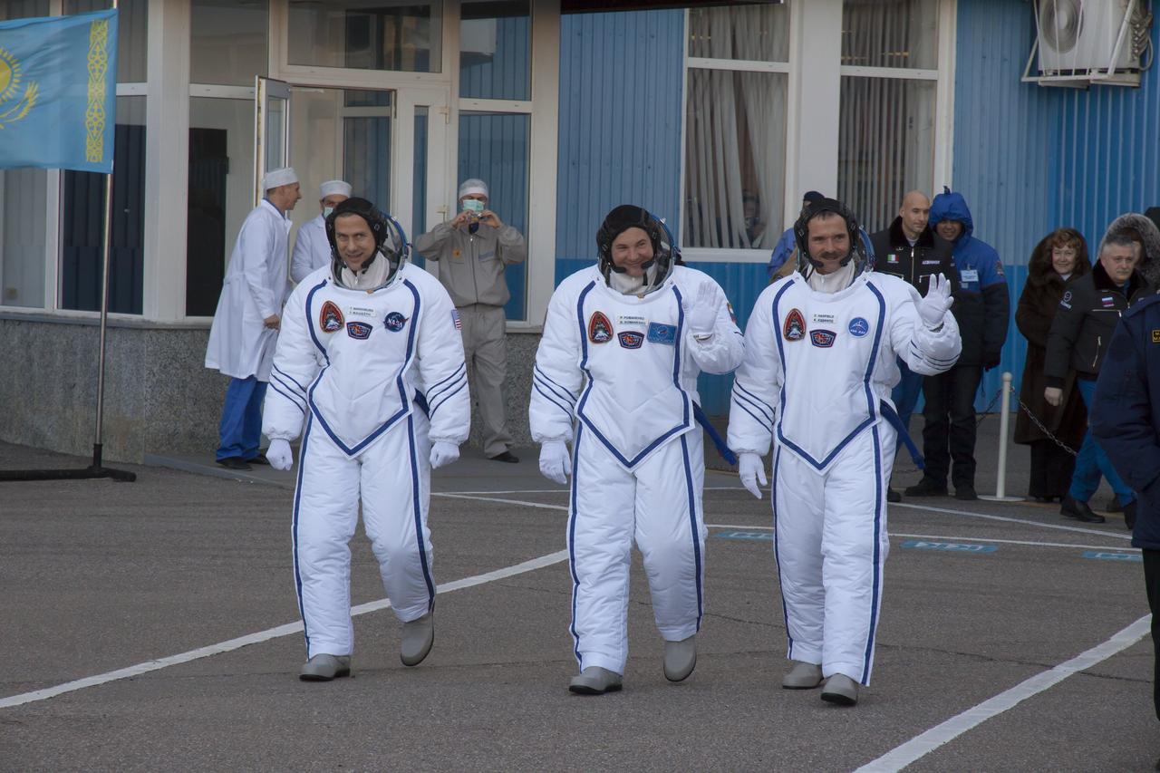 Expedition 34/35 crew members, Flight Engineer Chris Hadfield of the Canadian Space Agency (CSA), left, Soyuz Commander Roman Romanenko, and Flight Engineer Tom Marshburn of NASA, right, depart Bulding 254 at the Baikonur Cosmodrome to head to the launch pad where they will board their Soyuz TMA-07M rocket, on Wednesday, Dec. 19, 2012, in Baikonur, Kazakhstan. The crew are donning special cold-weather suits over their Sokol suits to keep them insulated from the extreme sub-zero temperature. Launch of the Soyuz rocket will send Hadfield, Romanenko and Marshburn on a five-month mission aboard the International Space Station. Photo Credit: (NASA/Victor Zelentsov)