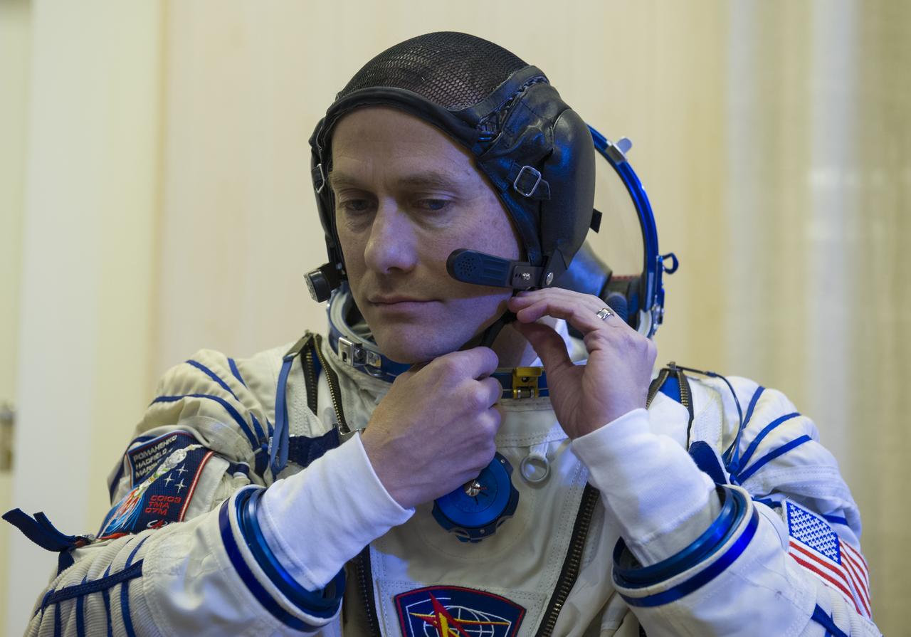 Expedition 34/35 Soyuz NASA Flight Engineer Tom Marshburn is helped into his Russian Sokol suit as he and fellow cremates, Soyuz Commander Roman Romanenko and Flight Engineer Chris Hadfield prepare for their Soyuz launch to the International Space Station, on Wednesday, Dec. 19, 2012, in Baikonur, Kazakhstan. Launch of the Soyuz rocket will send Marshburn, Romanenko and Hadfield on a five-month mission aboard the International Space Station. Photo Credit: (NASA/GCTC/Andrey Shelepin)