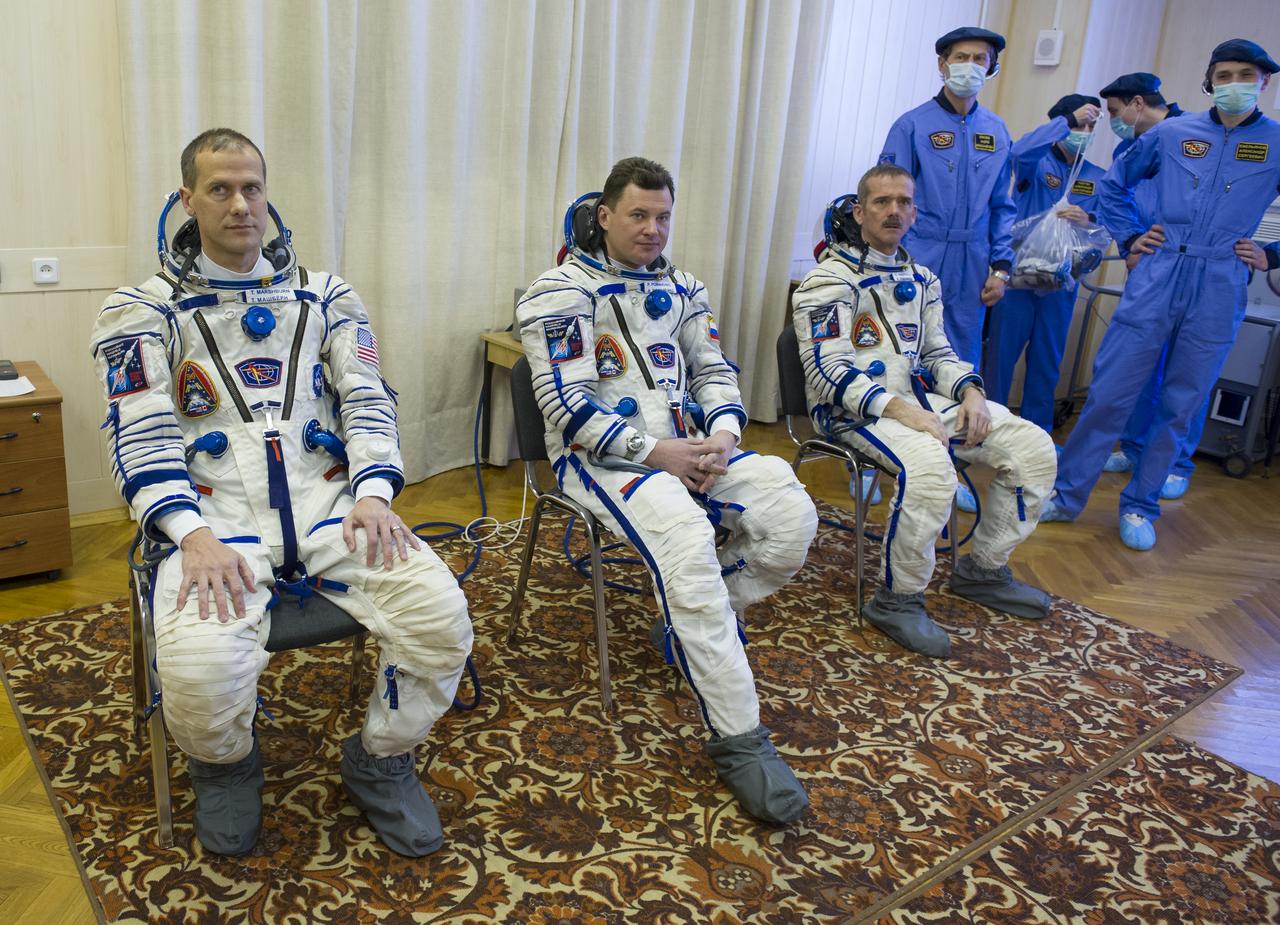 Expedition 34/35 Flight Engineer Tom Marshburn, left, Soyuz Commander Roman Romanenko, and Flight Engineer Chris Hadfield, right, are seen after donning their Russian Sokol suits in preparation for their launch, on Wednesday, Dec. 19, 2012, at the Baikonur Cosmodrome in Kazakhstan. Launch of the Soyuz rocket will send Marshburn, Romanenko and Hadfield on a five-month mission aboard the International Space Station. Photo Credit: (NASA/GCTC/Andrey Shelepin)