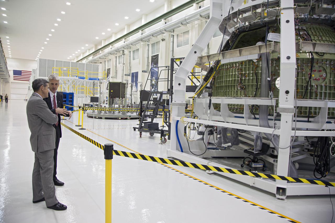 CAPE CANAVERAL, Fla. – Kennedy Space Center Director Bob Cabana, left, talks with Scott Wilson, NASA's Orion production manager at the Florida Spaceport. A special fixture surrounds the Orion spacecraft inside the high bay of Kennedy's Operations and Checkout Building.   Orion is the exploration spacecraft designed to carry crews to space beyond low Earth orbit. It will provide emergency abort capability, sustain the crew during the space travel and provide safe re-entry from deep space return velocities. The first unpiloted test flight of the Orion is scheduled to launch in 2014 atop a Delta IV rocket and in 2017 on a Space Launch System rocket. For more information, visit http:__www.nasa.gov_orion Photo credit: NASA_Kim Shiflett