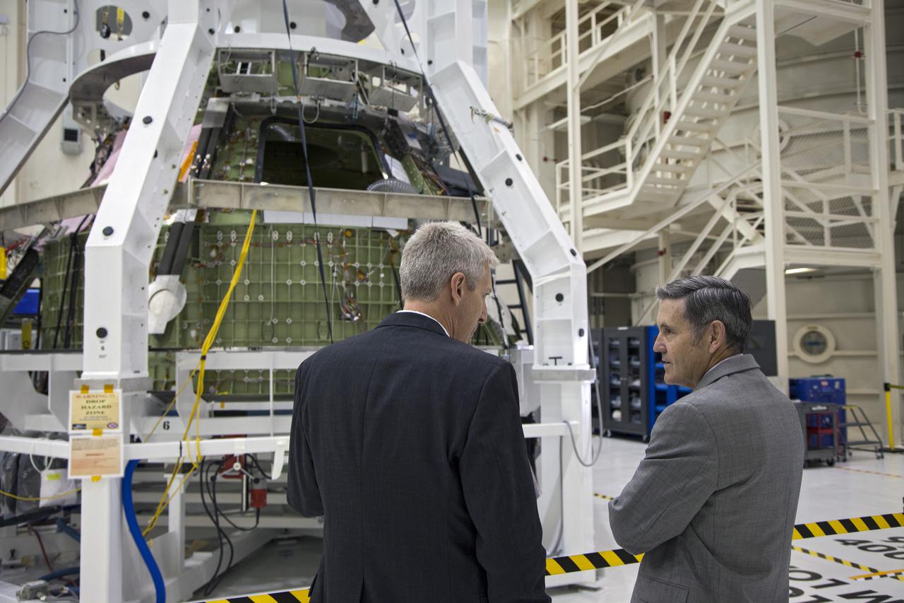 CAPE CANAVERAL, Fla. – Kennedy Space Center Director Bob Cabana, right, talks with Scott Wilson, NASA's Orion production manager at the Florida Spaceport. A special fixture surrounds the Orion spacecraft inside the high bay of Kennedy's Operations and Checkout Building.  Orion is the exploration spacecraft designed to carry crews to space beyond low Earth orbit. It will provide emergency abort capability, sustain the crew during the space travel and provide safe re-entry from deep space return velocities. The first unpiloted test flight of the Orion is scheduled to launch in 2014 atop a Delta IV rocket and in 2017 on a Space Launch System rocket. For more information, visit http:__www.nasa.gov_orion Photo credit: NASA_Kim Shiflett