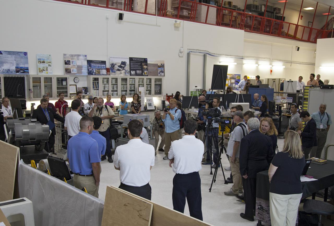 CAPE CANAVERAL, Fla. -- Dr. Mason Peck, second from left, NASA's chief technologist, and a team of NASA's innovative engineers discuss some of NASA's cutting-edge projects with media representatives touring the Swamp Works at NASA's Kennedy Space Center in Florida.   Kennedy's Swamp Works provides rapid, innovative and cost-effective exploration mission solutions, leveraging partnerships across NASA, industry and academia. Kennedy's research and technology mission is to improve spaceports on Earth, as well as lay the groundwork for establishing spaceports at destinations in space. For more information, visit http:__www.nasa.gov_centers_kennedy_exploration_researchtech_index.html.  Photo credit: NASA_Frankie Martin