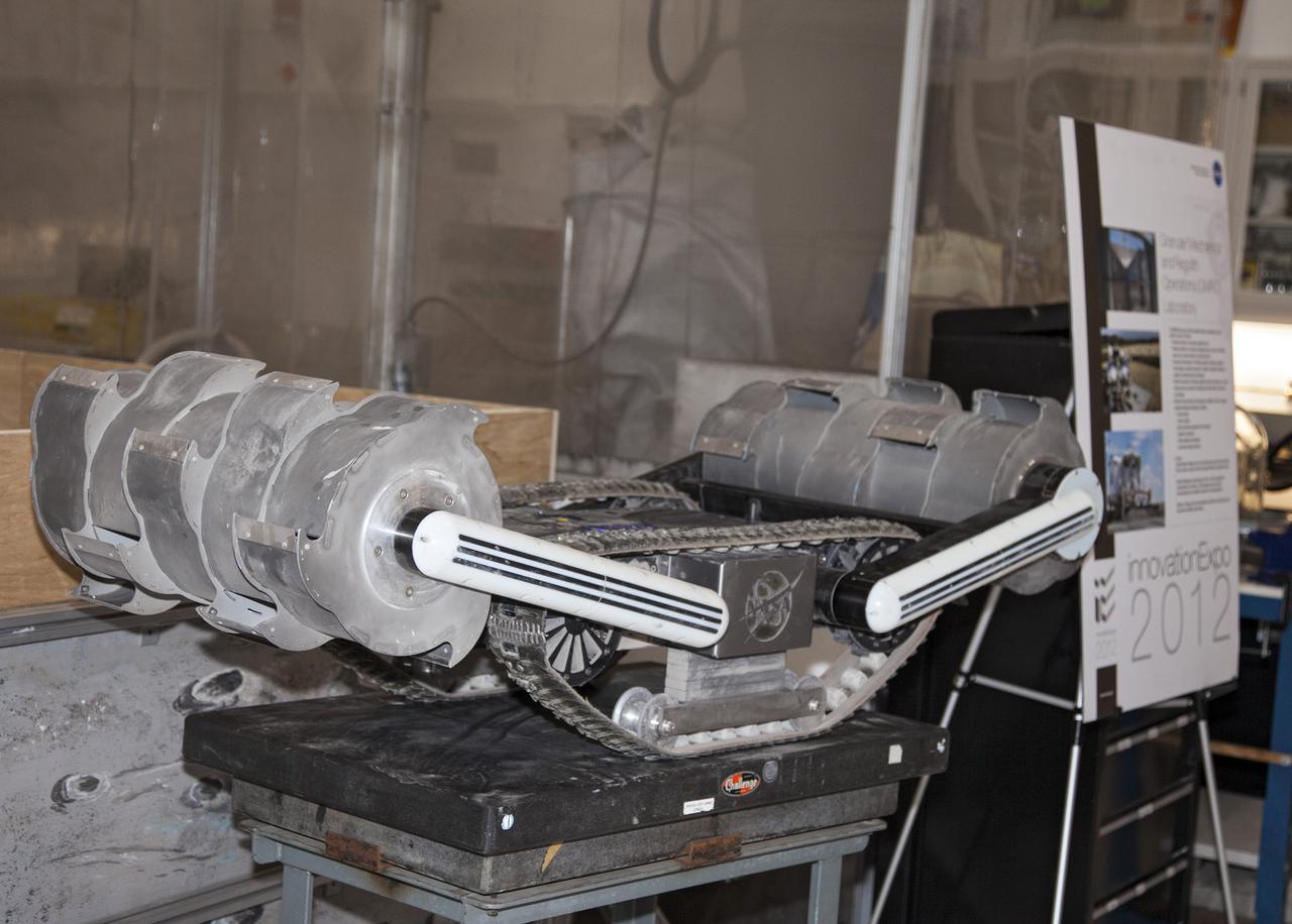 CAPE CANAVERAL, Fla. -- NASA's Regolith Advanced Surface Systems Operations Robot, or RASSOR, is ready to demonstrate its unique skills during a media tour of the Granular Mechanics and Regolith Operations, or GMRO, Lab in the Swamp Works at NASA's Kennedy Space Center in Florida.  RASSOR, lunar soil excavator, resembles a small tank chassis with a drum at either end, each attached with arms. The drums, one of the robot's most innovative feature, are mounted on moving arms, allowing the robot to step and climb over obstacles.     Kennedy's Swamp Works provides rapid, innovative and cost-effective exploration mission solutions, leveraging partnerships across NASA, industry and academia. Kennedy's research and technology mission is to improve spaceports on Earth, as well as lay the groundwork for establishing spaceports at destinations in space. For more information, visit http:__www.nasa.gov_centers_kennedy_exploration_researchtech_index.html.  Photo credit: NASA_Frankie Martin