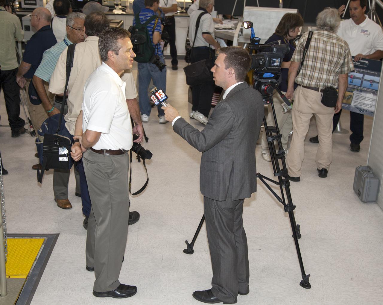CAPE CANAVERAL, Fla. -- Robert Mueller, chief of the Surface Systems Office, is interviewed by a representative of the media during a tour of the Swamp Works at NASA's Kennedy Space Center in Florida.   Kennedy's Swamp Works provides rapid, innovative and cost-effective exploration mission solutions, leveraging partnerships across NASA, industry and academia. Kennedy's research and technology mission is to improve spaceports on Earth, as well as lay the groundwork for establishing spaceports at destinations in space. For more information, visit http:__www.nasa.gov_centers_kennedy_exploration_researchtech_index.html.  Photo credit: NASA_Frankie Martin