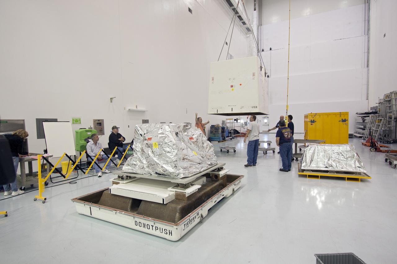 CAPE CANAVERAL, Fla. -- Inside the Space Station Processing Facility at NASA's Kennedy Space Center in Florida, technicians prepare to lower the cover of a shipping container that will enclose the orbital replacement unit for the space station's utility transfer assembly.   The unit is one of the payloads processed at Kennedy that will be flown to Japan for the HTV-4 launch to the station, which is currently scheduled for this summer. Photo credit: NASA_Jim Grossmann