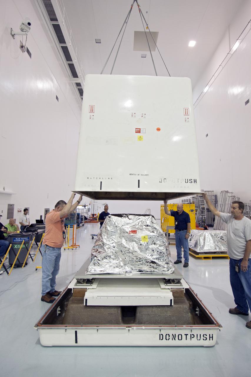 CAPE CANAVERAL, Fla. -- Inside the Space Station Processing Facility at NASA's Kennedy Space Center in Florida, technicians begin to lower the cover of a shipping container that will enclose the orbital replacement unit for the space station's utility transfer assembly.    The unit is one of the payloads processed at Kennedy that will be flown to Japan for the HTV-4 launch to the station, which is currently scheduled for this summer. Photo credit: NASA_Jim Grossmann