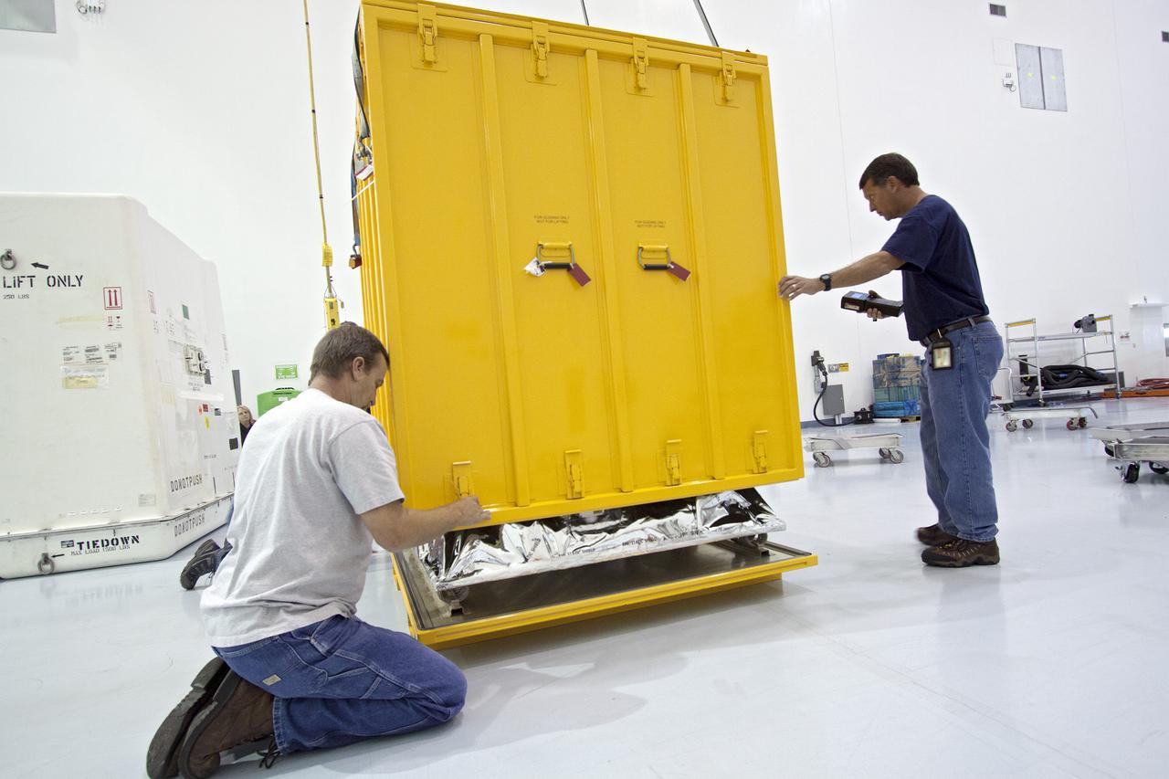 CAPE CANAVERAL, Fla. -- Inside the Space Station Processing Facility at NASA's Kennedy Space Center in Florida, technicians lower the cover of a shipping container that will enclose the orbital replacement unit for the space station's main bus switching unit.  The unit is one of the payloads processed at Kennedy that will be flown to Japan for the HTV-4 launch to the station, which is currently scheduled for this summer. Photo credit: NASA_Jim Grossmann