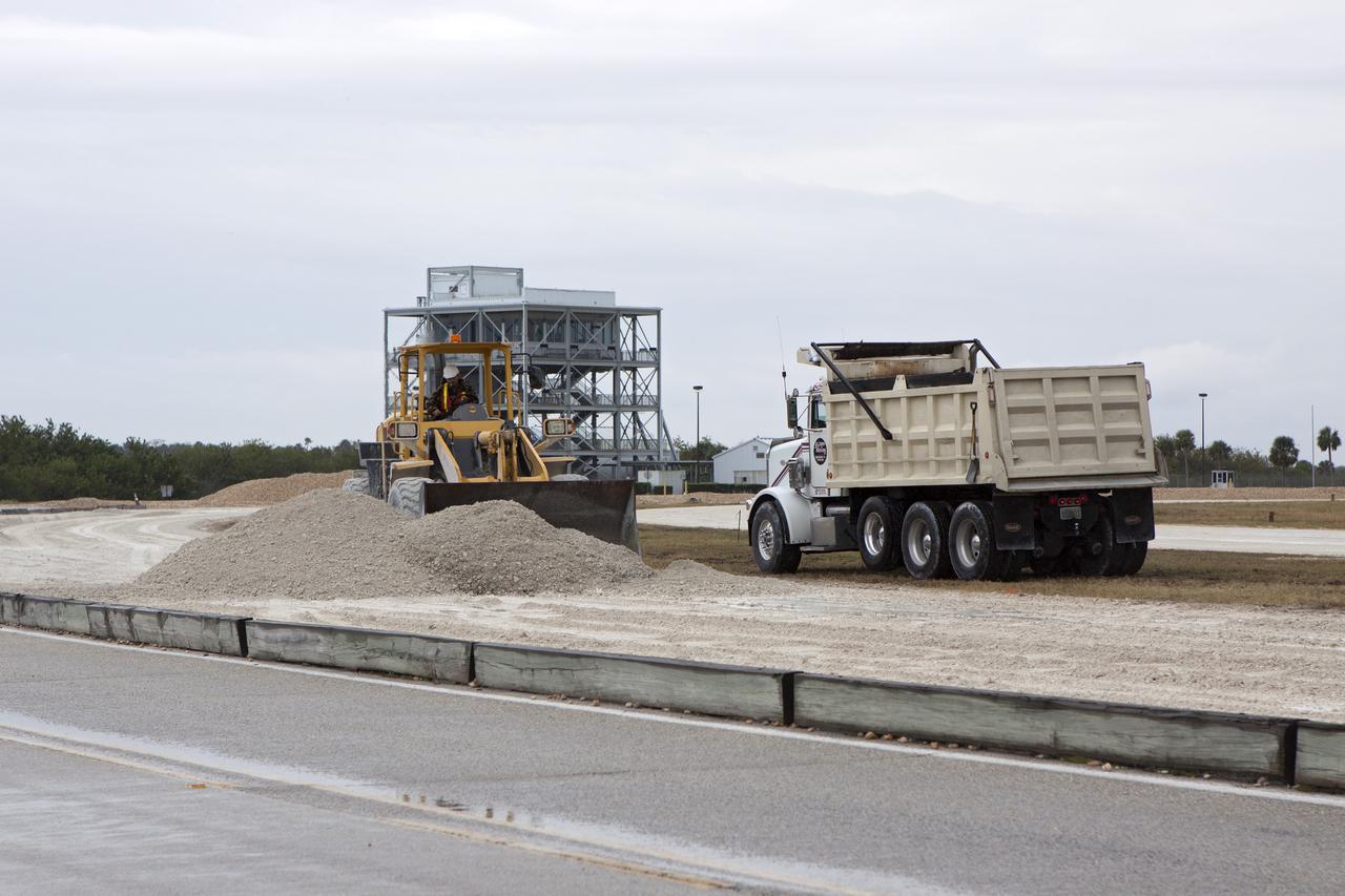 CAPE CANAVERAL, Fla. – Workers from Canaveral Construction in Mims, Fla., remove the Alabama river rock from the crawlerway near the turn off to Launch Pad 39B at NASA’s Kennedy Space Center in Florida. In the background is the Launch Viewing Gantry that is a Kennedy Space Center Visitor Complex tour stop.  The crawlerway is being upgraded to improve the foundation and prepare it to support the weight of NASA’s Space Launch System, or SLS, and mobile launcher on the crawler-transporter during rollout. Workers are removing the original Alabama river rock and restoring the layer of lime rock below to its original depth. Then new river rock will be added on top. The Ground Systems Development and Operations, or GSDO, Program office at Kennedy is leading the center’s transformation to safely handle a variety of rockets and spacecraft. For more information about GSDO, visit: http:__go.nasa.gov_groundsystems.  Photo credit: NASA_Jim Grossmann
