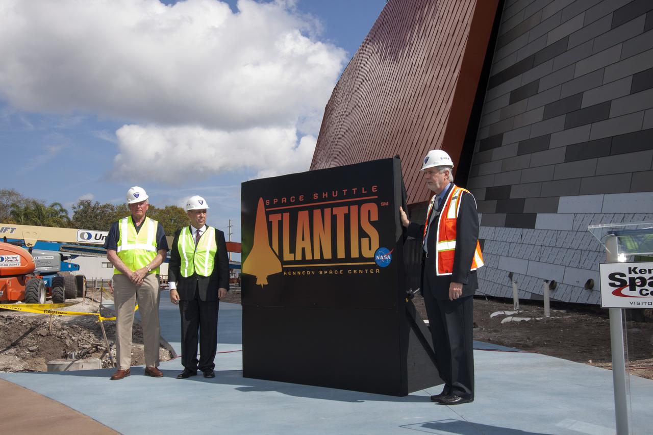 CAPE CANAVERAL, Fla. -- From the left, former NASA astronaut Jon McBride, Rick Abramson, president of Delaware North Companies Parks and Resorts, and Bill Moore, Delaware North's chief operating officer of the visitor complex, pose with the Atlantis exhibit's newly designed logo. Last November, the space shuttle Atlantis made its historic final journey to its new home, traveling 10 miles from the Kennedy Space Center's Vehicle Assembly Building to the spaceport's visitor complex. The new $100 million Atlantis facility will be a 90,000-square-foot, interactive exhibit that tells the story of the 30-year Space Shuttle Program and highlights the future of space exploration. Photo credit: NASA_Jim Grossmann