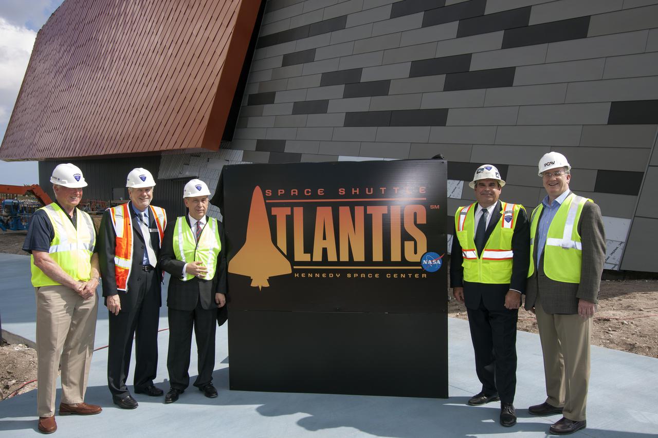 CAPE CANAVERAL, Fla. -- Posing with the newly unveiled logo for the 'Space Shuttle Atlantis' exhibit are, from the left, former NASA astronaut Jon McBride, Bill Moore, Delaware North Companies Parks and Resorts chief operating officer of the visitor complex, Rick Abramson, Delaware North president, Tim Macy, Delaware North director of project development and Mike Konzen, PGAV Destinations chairman and chief Executive Officer. Last November, the space shuttle Atlantis made its historic final journey to its new home, traveling 10 miles from the Kennedy Space Center's Vehicle Assembly Building to the spaceport's visitor complex. The new $100 million Atlantis facility will be a 90,000-square-foot, interactive exhibit that tells the story of the 30-year Space Shuttle Program and highlights the future of space exploration. Photo credit: NASA_Jim Grossmann