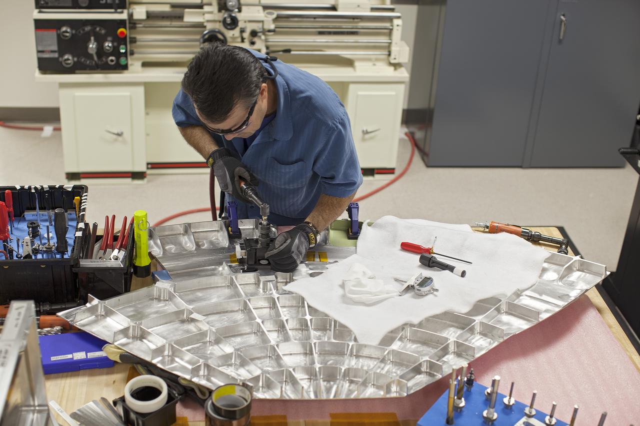 CAPE CANAVERAL, Fla. -- Inside the Operations and Checkout Building high bay at NASA’s Kennedy Space Center in Florida, a technician practices a procedure to repair cracks on the agency’s Orion Exploration Flight Test 1 crew module, during a dry run. During proof pressure testing on the vehicle, the spacecraft sustained three cracks in the aft bulkhead. A team composed of Lockheed Martin and NASA engineers designed a set of brackets that will be used to repair the area, as well as tooling to fix the cracked structure. Orion is the exploration spacecraft designed to carry humans further into space than ever before. It will provide emergency abort capability, sustain the crew during the space travel and provide safe re-entry from deep space return velocities. Orion’s first unpiloted test flight is scheduled to launch in 2014 atop a United Launch Alliance Delta IV heavy rocket. A second uncrewed flight test is scheduled for 2017 on the Space Launch System rocket. For more information, visit http:__www.nasa.gov_orion. Photo credit: NASA_Dimitri Gerondidakis