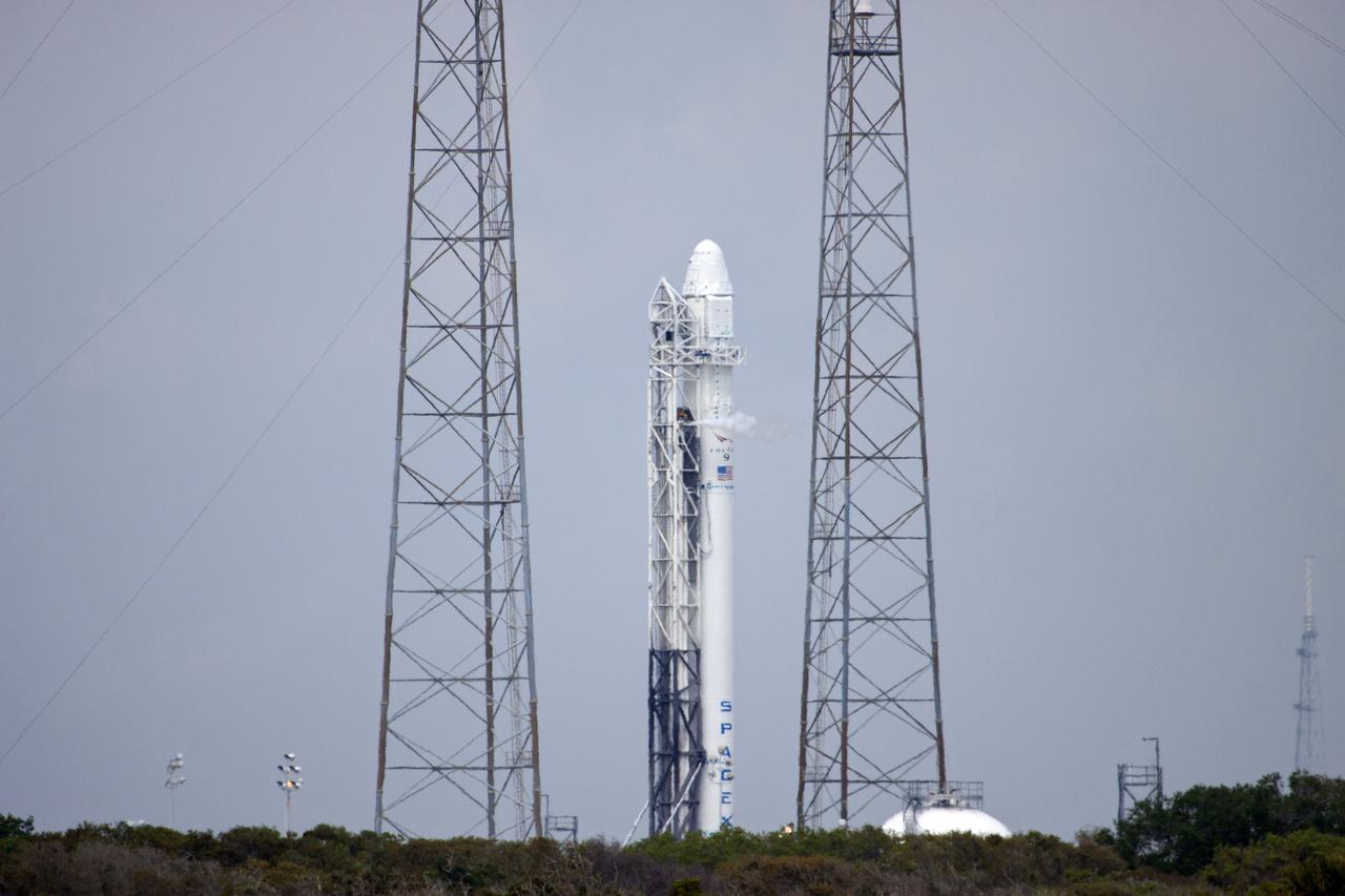 CAPE CANAVERAL, Fla. - Flanked by lightning protection catenary towers at Launch Complex 40, the SpaceX Falcon 9 rocket, topped by the Dragon spacecraft, awaits a test firing of the vehicle's nine Merlin first-stage engines. The test is part of SpaceX 2 prelaunch preparations at Cape Canaveral Air Force Station in Florida.  Liftoff of the SpaceX Falcon 9 rocket and Dragon spacecraft is planned for March 1, 2013, at 10:10 a.m. EST, from Space Launch Complex-40 at Cape Canaveral Air Force Station, Fla. Dragon will be making its third trip to the space station. It will carry supplies and experiments to the orbiting laboratory. The mission is the second of 12 SpaceX flights contracted by NASA to resupply the space station. For more information, visit http:__www.nasa.gov_mission_pages_station_structure_launch_spacex2-feature.html Photo credit: NASA_Jim Grossmann