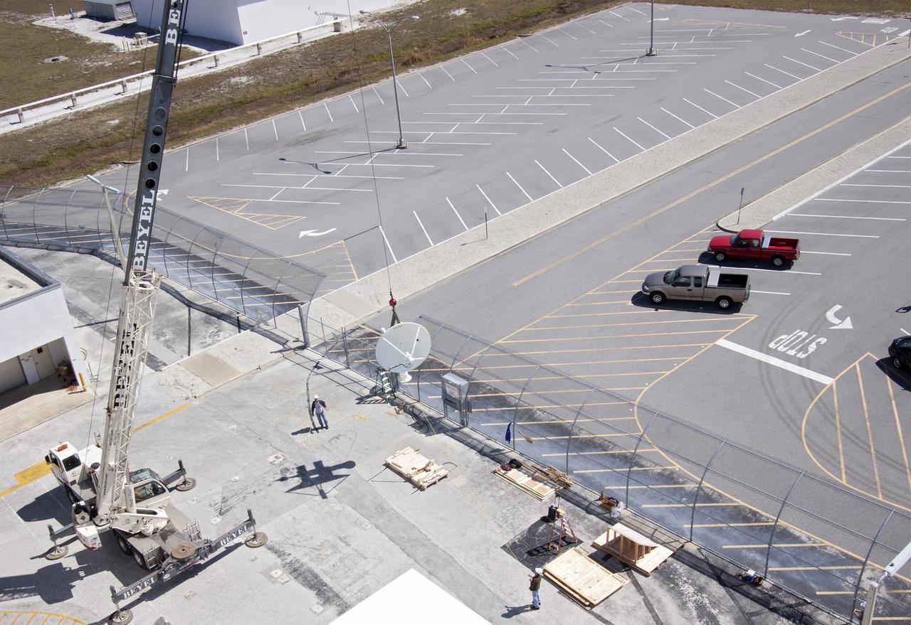 CAPE CANAVERAL, Fla. – Workers use a crane to install a new parabolic telemetry antenna and tracker camera to the roof of the Launch Control Center, or LCC, in Launch Complex 39 at NASA's Kennedy Space Center in Florida. This antenna and camera system is the first of three that will be installed on the LCC roof for the Radio Frequency and Telemetry Station RFTS, which will be used to monitor radio frequency communications from a launch vehicle at Launch Pad 39A or B as well as provide radio frequency relay for a launch vehicle in the Vehicle Assembly Building. The RFTS replaces the shuttle-era communications and tracking labs at Kennedy. The modern RFTS checkout station is designed to primarily support NASA's Space Launch System, or SLS, and Orion spacecraft, but can support multi-user radio frequency tests as the space center transitions to support a variety of rockets and spacecraft.     For more information on the modernization efforts at Kennedy, visit the Ground Systems Development and Operations, or GSDO, website at http:__go.nasa.gov_groundsystems. Photo credit: NASA_Jim Grossmann