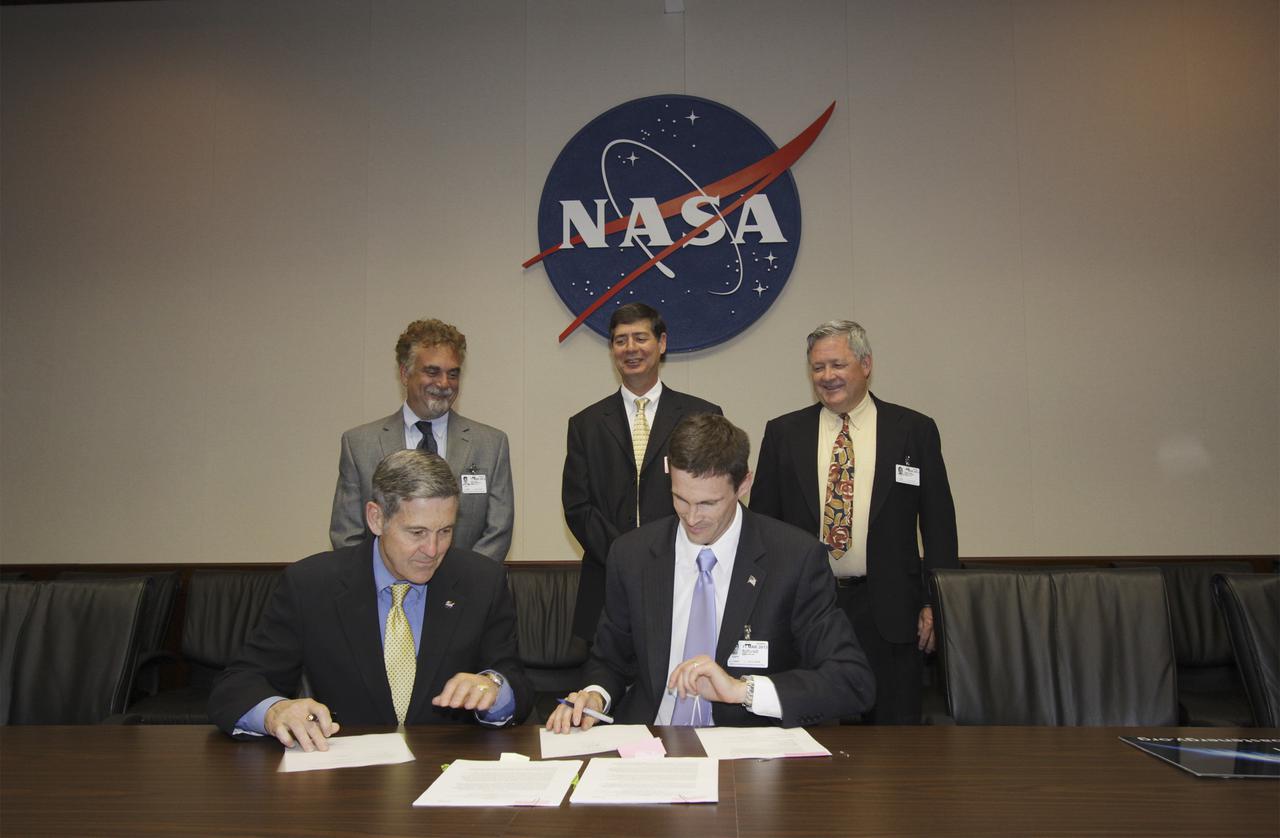 CAPE CANAVERAL, Fla. -- Kennedy Space Center Director Bob Cabana, left, joins Mike Aller, executive director of the Space Coast Energy Consortium, in signing a Space Act Agreement to help transition the Kennedy Space Center from a historically government-only launch facility to a multiuser spaceport. The partnership defines how the space agency will serve both government and commercial renewable energy initiatives. Looking on, from the left, are Scott Lewit, chairman of the SCEC’s board of directors, Bennett Boucher, SCEC board member, and Rodger Rees, SCEC chief financial officer.   The Cape Canaveral-based energy consortium is an industry-led nonprofit association created to identify and create innovative energy opportunities for the Space Coast and Florida. The organization was formed by community and industry leaders to assist with the post-space shuttle transition by building networks among local businesses with resources across the country. Photo credit: NASA_Jim Grossmann