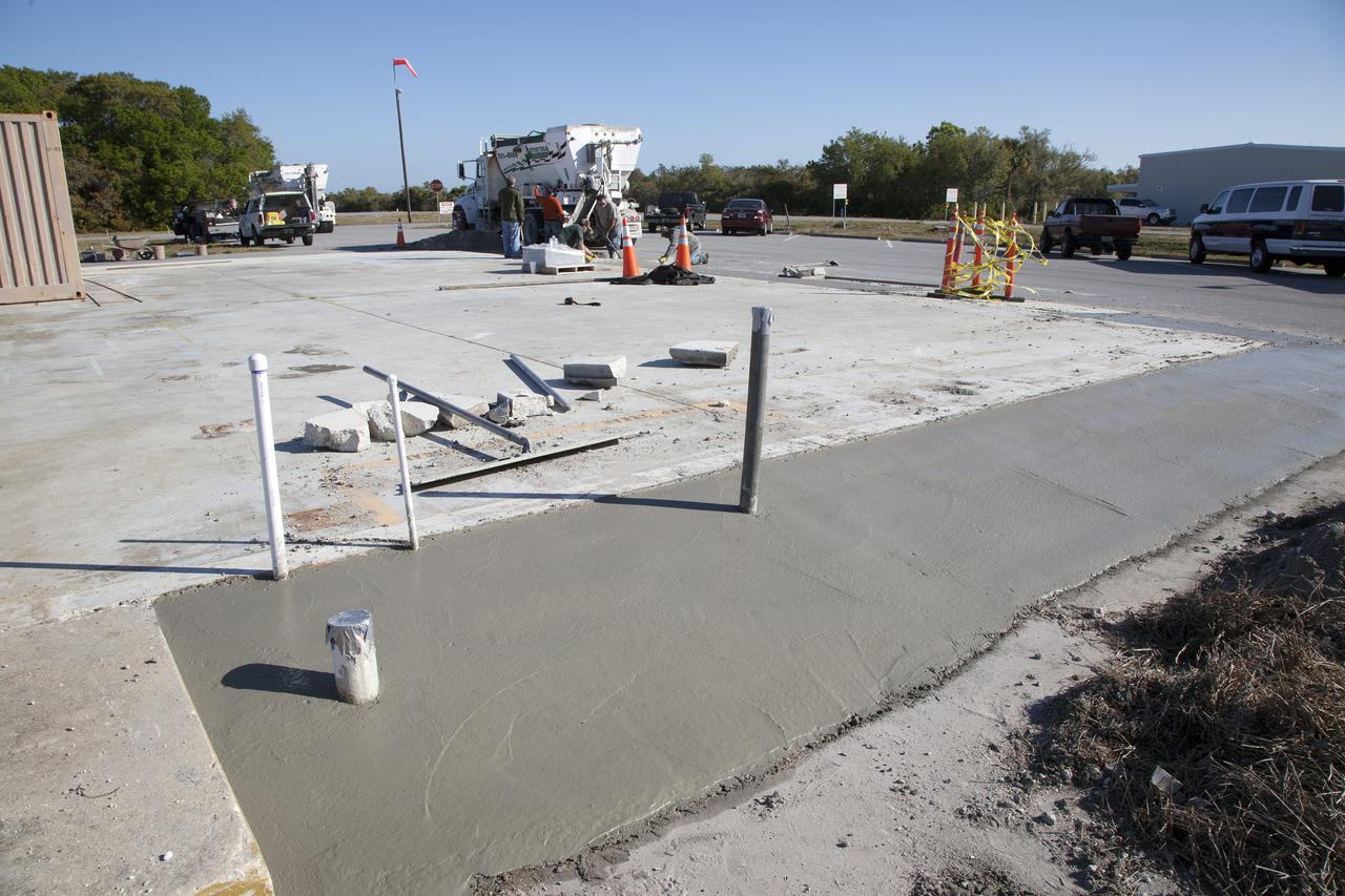 CAPE CANAVERAL, Fla. – Workers pour a concrete mix that utilizes spent material from sandblasting projects at NASA's Kennedy Space Center in Florida. The experimental formula is being tested at the Propellants North facility at Kennedy and will undergo structural and other evaluations as part of a pilot project. Spent blast media, or SBM, makes up much of the waste deposited at the center's landfill and engineers are trying to develop ways to put the debris to use in other ways instead. Photo credit: NASA_Kim Shiflett