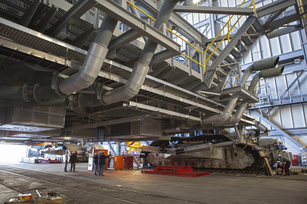 CAPE CANAVERAL, Fla. -- Technicians in the Vehicle Assembly Building at NASA’s Kennedy Space Center in Florida, prepare to jack crawler-transporter 2, or CT-2, four feet off the floor to facilitate removal of the roller bearing assemblies. After inspections, new assemblies will be installed.   The Ground Systems Development and Operations Program office at Kennedy is overseeing the upgrades to CT-2 so that it can carry NASA’s Space Launch System heavy-lift rocket and new Orion spacecraft to the launch pad. For more than 45 years the crawler-transporters were used to transport the mobile launcher platform and the Apollo-Saturn V rockets and, later, space shuttles to Launch Pads 39A and B. Photo credit: NASA_Dimitri Gerondidakis