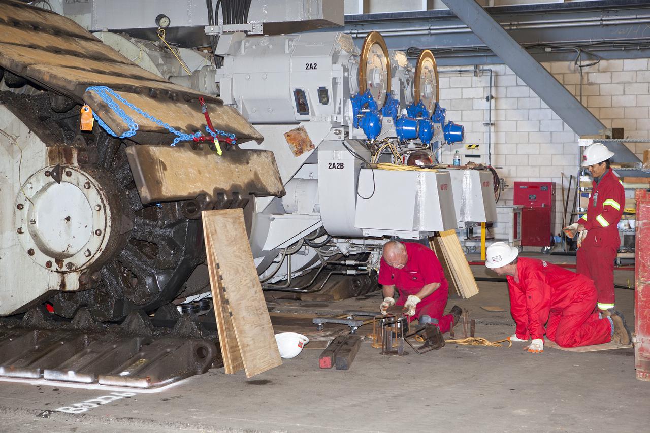 CAPE CANAVERAL, Fla. -- Technicians in the Vehicle Assembly Building at NASA’s Kennedy Space Center in Florida, prepare to jack crawler-transporter 2, or CT-2, four feet off the floor to facilitate removal of the roller bearing assemblies. After inspections, new assemblies will be installed.   The Ground Systems Development and Operations Program office at Kennedy is overseeing the upgrades to CT-2 so that it can carry NASA’s Space Launch System heavy-lift rocket and new Orion spacecraft to the launch pad. For more than 45 years the crawler-transporters were used to transport the mobile launcher platform and the Apollo-Saturn V rockets and, later, space shuttles to Launch Pads 39A and B. Photo credit: NASA_Dimitri Gerondidakis