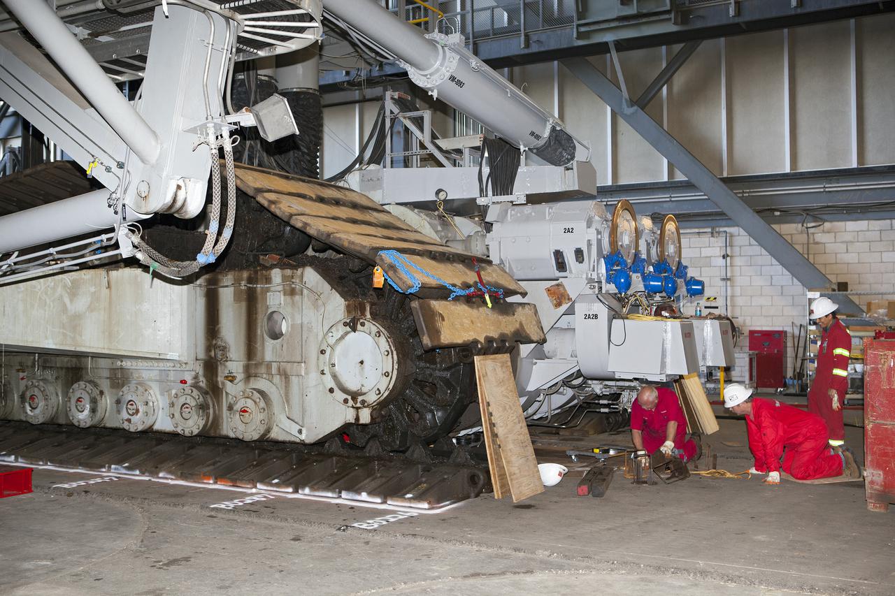 CAPE CANAVERAL, Fla. -- Technicians in the Vehicle Assembly Building at NASA’s Kennedy Space Center in Florida, prepare to jack crawler-transporter 2, or CT-2, four feet off the floor to facilitate removal of the roller bearing assemblies. After inspections, new assemblies will be installed.   The Ground Systems Development and Operations Program office at Kennedy is overseeing the upgrades to CT-2 so that it can carry NASA’s Space Launch System heavy-lift rocket and new Orion spacecraft to the launch pad. For more than 45 years the crawler-transporters were used to transport the mobile launcher platform and the Apollo-Saturn V rockets and, later, space shuttles to Launch Pads 39A and B. Photo credit: NASA_Dimitri Gerondidakis