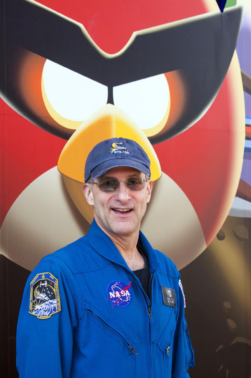 CAPE CANAVERAL, Fla. -- At NASA’s Kennedy Space Center Visitor Complex in Florida, NASA astronaut Don Pettit stands near the entrance to the new Angry Birds Space Encounter during the grand opening ceremony. Pettit spent a total of 12 months during two separate missions aboard the International Space Station and introduced Angry Birds Space while floating in zero gravity.  Finland-based Rovio Entertainment, the creator of the Angry Birds Space game, partnered with Kennedy Space Center to bring the beloved characters to life. It is the first Angry Birds interactive exhibit in the United States designed for people of all ages. The 4,485-square-foot facility hosts the space adventures of the Angry Birds as they travel into an intergalactic wormhole, come face-to-face with Space Pigs and discover heroic superpowers. Six interactive stations are designed to encourage children in science, technology, engineering and mathematics fields of study. Photo credit: NASA_Kim Shiflett