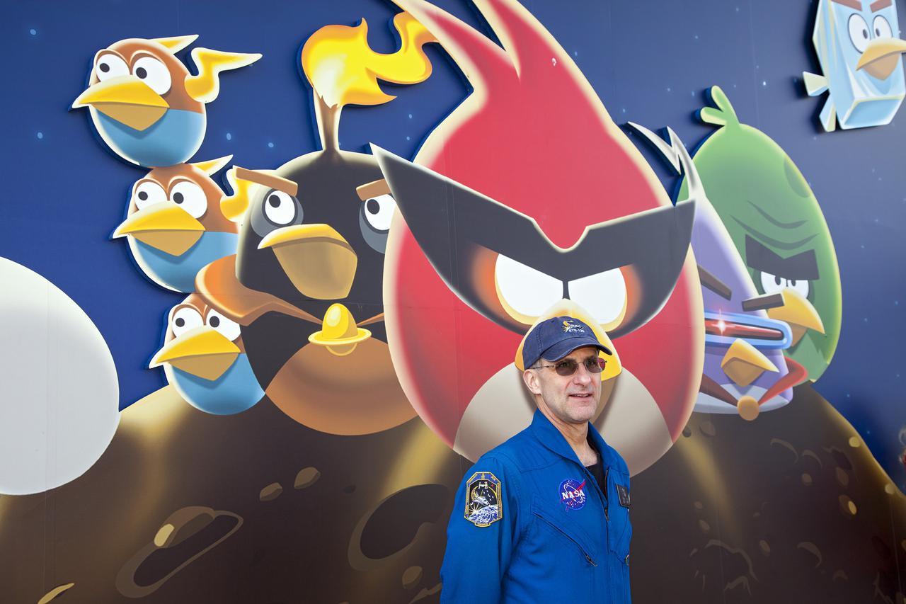 CAPE CANAVERAL, Fla. -- At NASA’s Kennedy Space Center Visitor Complex in Florida, NASA astronaut Don Pettit stands near the entrance to the new Angry Birds Space Encounter during the grand opening ceremony. Pettit spent a total of 12 months during two separate missions aboard the International Space Station and introduced Angry Birds Space while floating in zero gravity.  Finland-based Rovio Entertainment, the creator of the Angry Birds Space game, partnered with Kennedy Space Center to bring the beloved characters to life. It is the first Angry Birds interactive exhibit in the United States designed for people of all ages. The 4,485-square-foot facility hosts the space adventures of the Angry Birds as they travel into an intergalactic wormhole, come face-to-face with Space Pigs and discover heroic superpowers. Six interactive stations are designed to encourage children in science, technology, engineering and mathematics fields of study. Photo credit: NASA_Kim Shiflett