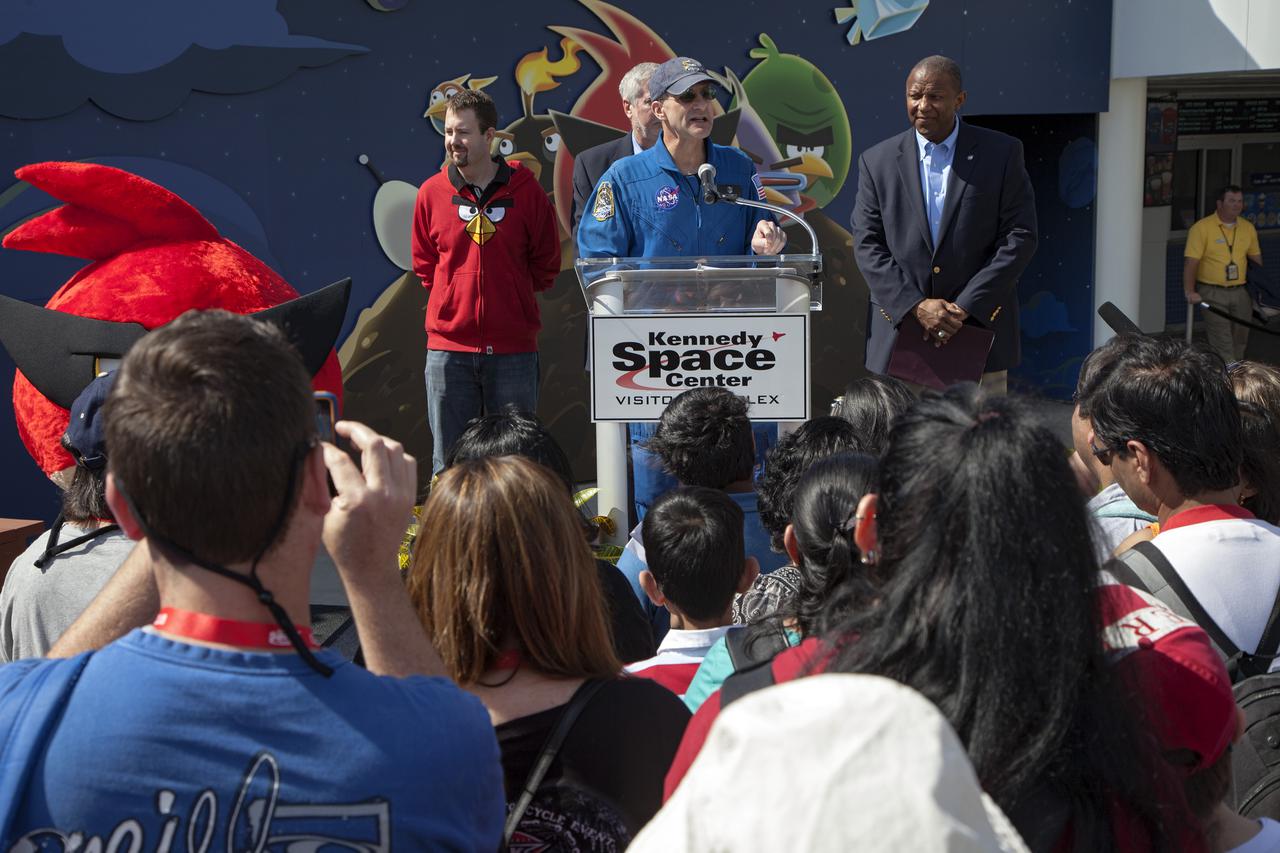 CAPE CANAVERAL, Fla. -- At NASA’s Kennedy Space Center Visitor Complex in Florida, NASA astronaut Don Pettit speaks to visitors during the grand opening of the new Angry Birds Space Encounter. Standing behind Pettit, from left are Dan Mitchell, director of location-based entertainment for Rovio Entertainment Bill Moore, chief operating officer with the KSC visitor complex and Kelvin Manning, associate deputy director of Kennedy Space Center. Also in the photo is Red Bird, one of the Angry Bird Space characters.  Finland-based Rovio Entertainment, the creator of the Angry Birds Space game, partnered with Kennedy Space Center to bring the beloved characters to life. It is the first Angry Birds interactive exhibit in the United States designed for people of all ages. The 4,485-square-foot facility hosts the space adventures of the Angry Birds as they travel into an intergalactic wormhole, come face-to-face with Space Pigs and discover heroic superpowers. Six interactive stations are designed to encourage children in science, technology, engineering and mathematics fields of study. Photo credit: NASA_Kim Shiflett
