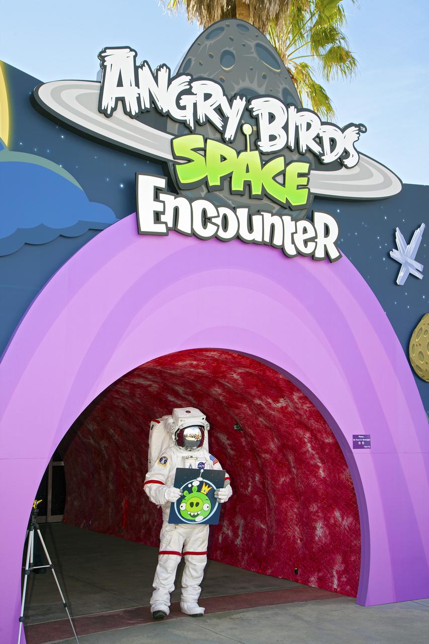 CAPE CANAVERAL, Fla. -- At NASA’s Kennedy Space Center Visitor Complex in Florida, the Spaceperson stands at the entrance of the new Angry Birds Space Encounter during the grand opening ceremony.    Finland-based Rovio Entertainment, the creator of the Angry Birds Space game, partnered with Kennedy Space Center to bring the beloved characters to life. It is the first Angry Birds interactive exhibit in the United States designed for people of all ages. The 4,485-square-foot facility hosts the space adventures of the Angry Birds as they travel into an intergalactic wormhole, come face-to-face with Space Pigs and discover heroic superpowers. Six interactive stations are designed to encourage children in science, technology, engineering and mathematics fields of study. Photo credit: NASA_Kim Shiflett