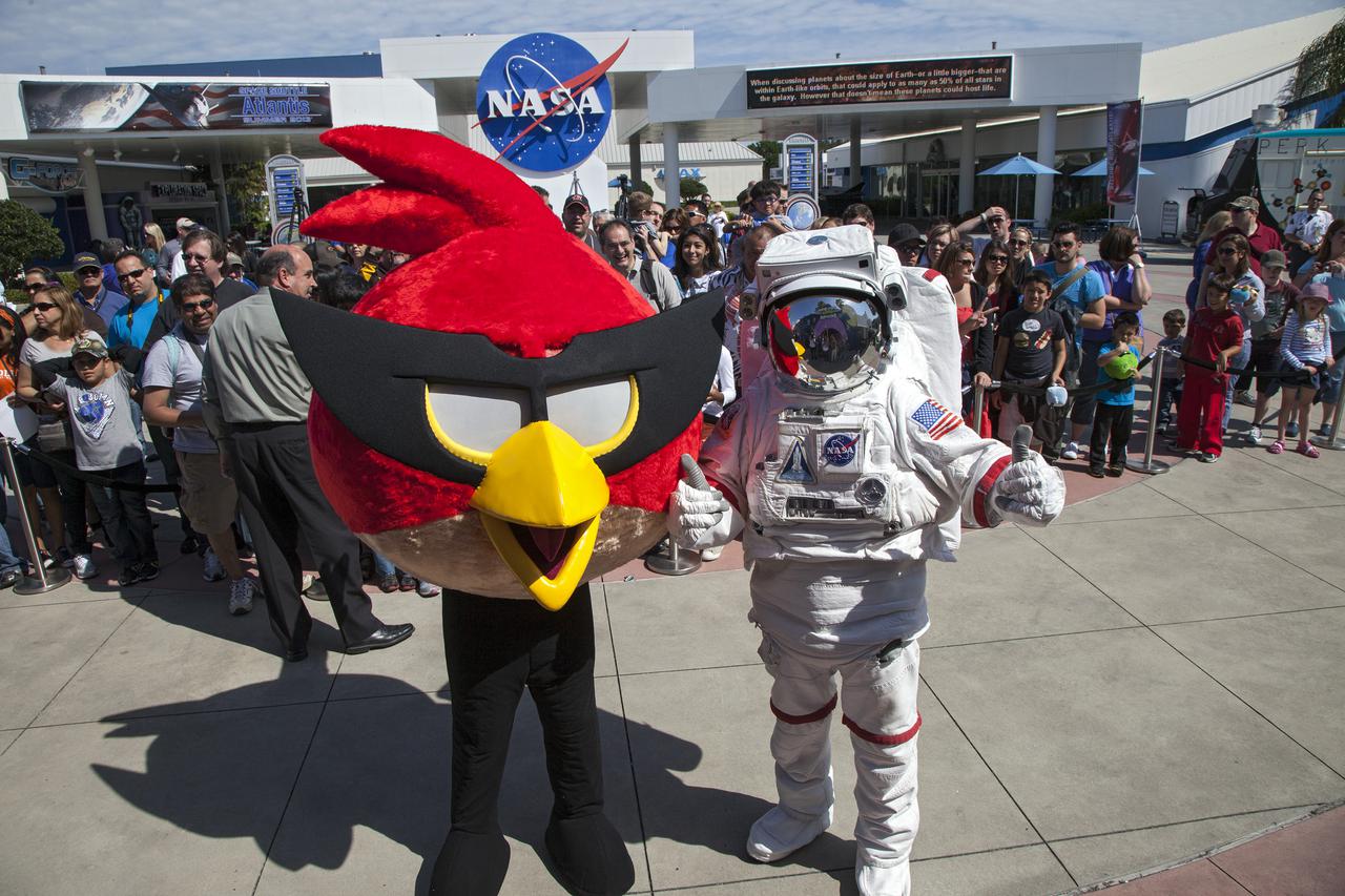 CAPE CANAVERAL, Fla. -- At NASA’s Kennedy Space Center Visitor Complex in Florida, the Spaceperson and Red Bird, one of the Angry Bird characters, welcome visitor to the Angry Birds Space Encounter grand opening ceremony.     Finland-based Rovio Entertainment, the creator of the Angry Birds Space game, partnered with Kennedy Space Center to bring the beloved characters to life. It is the first Angry Birds interactive exhibit in the United States designed for people of all ages. The 4,485-square-foot facility hosts the space adventures of the Angry Birds as they travel into an intergalactic wormhole, come face-to-face with Space Pigs and discover heroic superpowers. Six interactive stations are designed to encourage children in science, technology, engineering and mathematics fields of study. Photo credit: NASA_Kim Shiflett