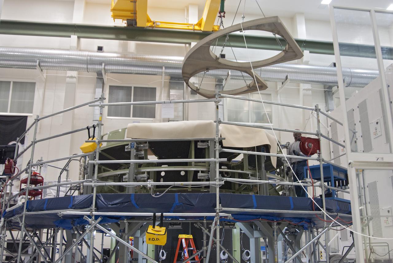 CAPE CANAVERAL, Fla. – Inside the Operations and Checkout Building high bay at NASA’s Kennedy Space Center in Florida, a bulkhead is lowered for installation on the Orion service module in preparation for Exploration Flight Test 1, or EFT-1. Orion is the exploration spacecraft designed to carry crews to space beyond low Earth orbit. It will provide emergency abort capability, sustain the crew during the space travel and provide safe re-entry from deep space return velocities. Orion’s first unpiloted test flight is scheduled to launch in 2014 atop a United Launch Alliance Delta IV heavy rocket. A second uncrewed flight test is scheduled for 2017 on the Space Launch System rocket. For more information, visit http:__www.nasa.gov_orion. Photo credit: NASA_Charisse Nahser