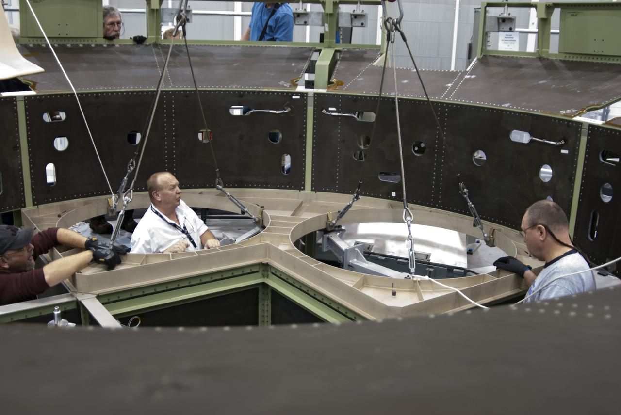 CAPE CANAVERAL, Fla. – Inside the Operations and Checkout Building high bay at NASA’s Kennedy Space Center in Florida, technicians help guide a bulkhead as it is lowered for installation on the Orion service module in preparation for Exploration Flight Test 1, or EFT-1. Orion is the exploration spacecraft designed to carry crews to space beyond low Earth orbit. It will provide emergency abort capability, sustain the crew during the space travel and provide safe re-entry from deep space return velocities. Orion’s first unpiloted test flight is scheduled to launch in 2014 atop a United Launch Alliance Delta IV heavy rocket. A second uncrewed flight test is scheduled for 2017 on the Space Launch System rocket. For more information, visit http:__www.nasa.gov_orion. Photo credit: NASA_Charisse Nahser
