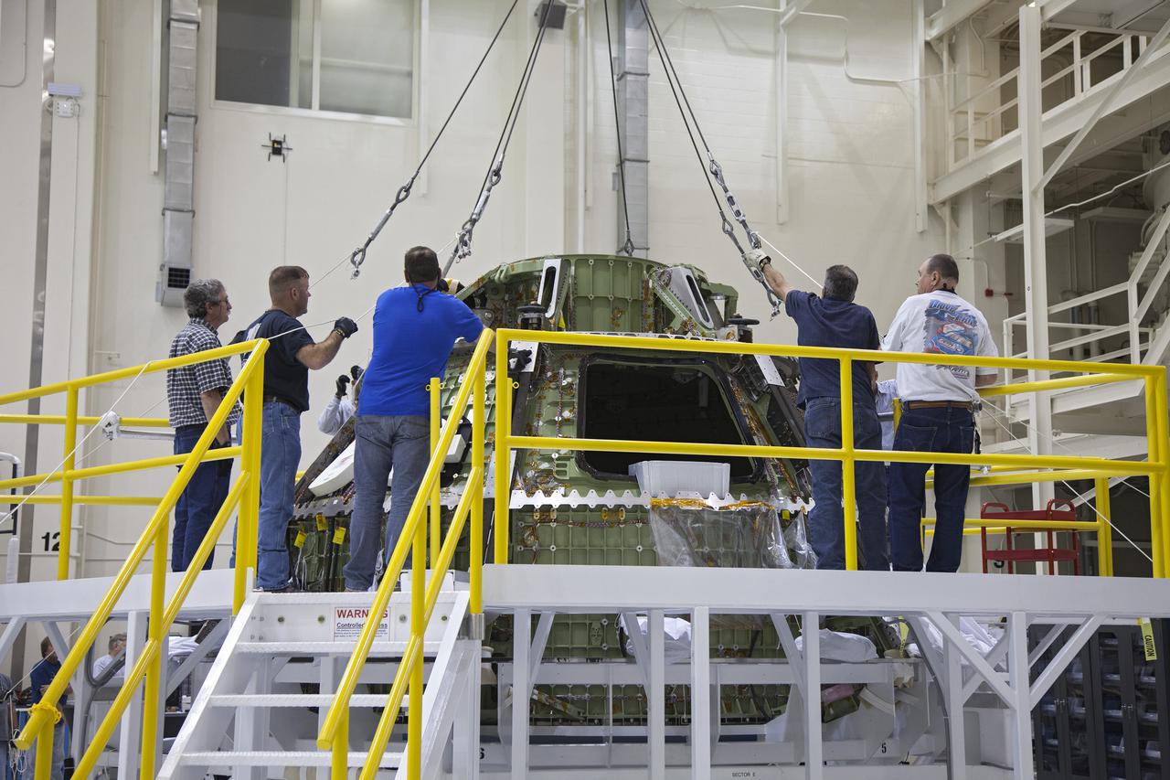 CAPE CANAVERAL, Fla. -- Inside the Operations and Checkout Building high bay at NASA’s Kennedy Space Center in Florida, workers prepare the Orion crew module for its move from a processing stand to a dolly. Orion is being prepared for Exploration Flight Test 1, or EFT-1. Orion is the exploration spacecraft designed to carry crews to space beyond low Earth orbit. It will provide emergency abort capability, sustain the crew during the space travel and provide safe re-entry from deep space return velocities. Orion’s first unpiloted test flight is scheduled to launch in 2014 atop a United Launch Alliance Delta IV heavy rocket. A second uncrewed flight test is scheduled for 2017 on the Space Launch System rocket. For more information, visit http:__www.nasa.gov_orion. Photo credit: NASA_Frankie Martin