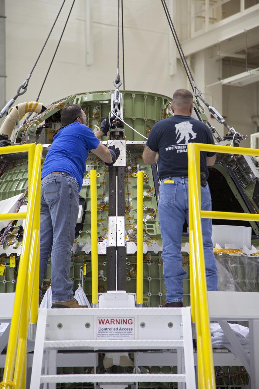 CAPE CANAVERAL, Fla. -- Inside the Operations and Checkout Building high bay at NASA’s Kennedy Space Center in Florida, workers prepare the Orion crew module for its move from a processing stand to a dolly. Orion is being prepared for Exploration Flight Test 1, or EFT-1. Orion is the exploration spacecraft designed to carry crews to space beyond low Earth orbit. It will provide emergency abort capability, sustain the crew during the space travel and provide safe re-entry from deep space return velocities. Orion’s first unpiloted test flight is scheduled to launch in 2014 atop a United Launch Alliance Delta IV heavy rocket. A second uncrewed flight test is scheduled for 2017 on the Space Launch System rocket. For more information, visit http:__www.nasa.gov_orion. Photo credit: NASA_Frankie Martin