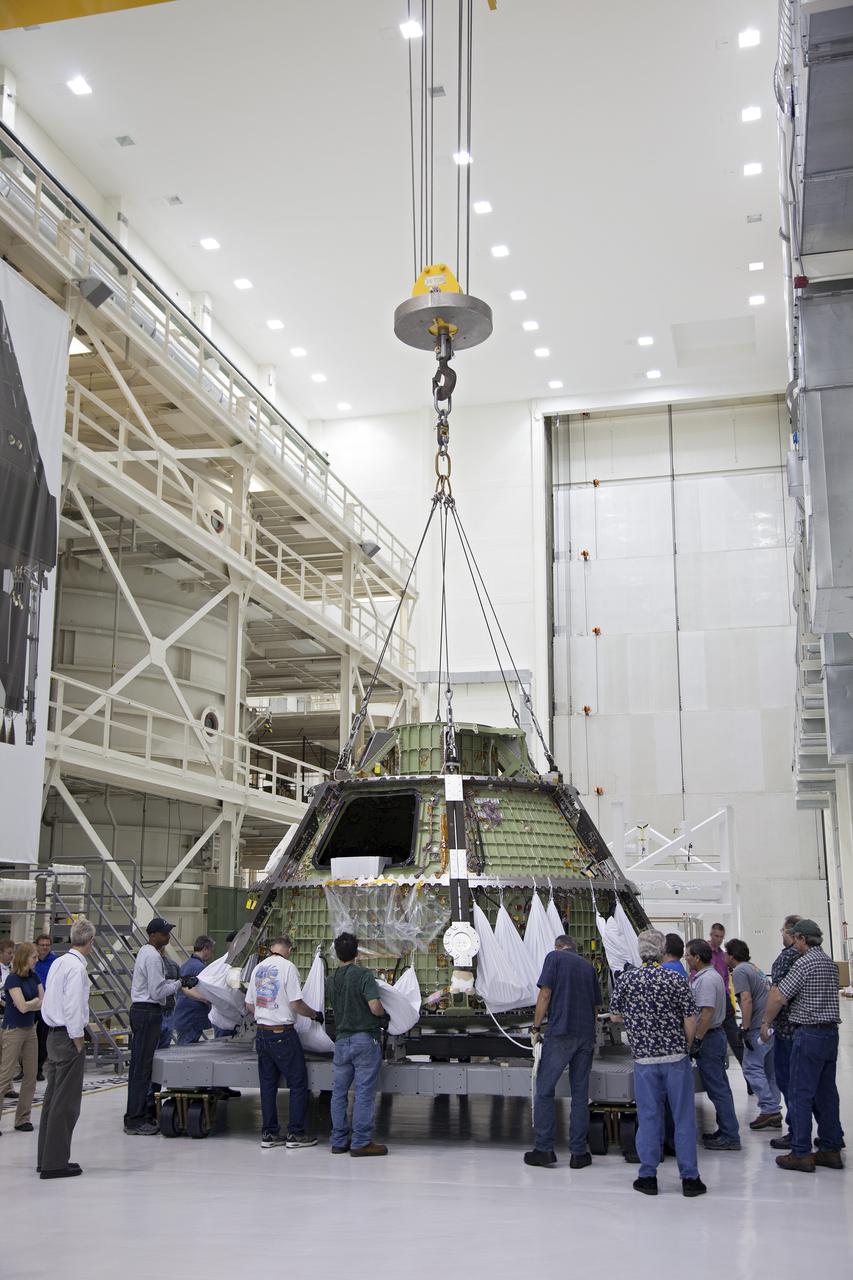 CAPE CANAVERAL, Fla. -- Inside the Operations and Checkout Building high bay at NASA’s Kennedy Space Center in Florida, workers monitor the progress as a crane lowers the Orion crew module onto a dolly. Orion is being prepared for Exploration Flight Test 1, or EFT-1. Orion is the exploration spacecraft designed to carry crews to space beyond low Earth orbit. It will provide emergency abort capability, sustain the crew during the space travel and provide safe re-entry from deep space return velocities. Orion’s first unpiloted test flight is scheduled to launch in 2014 atop a United Launch Alliance Delta IV heavy rocket. A second uncrewed flight test is scheduled for 2017 on the Space Launch System rocket. For more information, visit http:__www.nasa.gov_orion. Photo credit: NASA_Frankie Martin