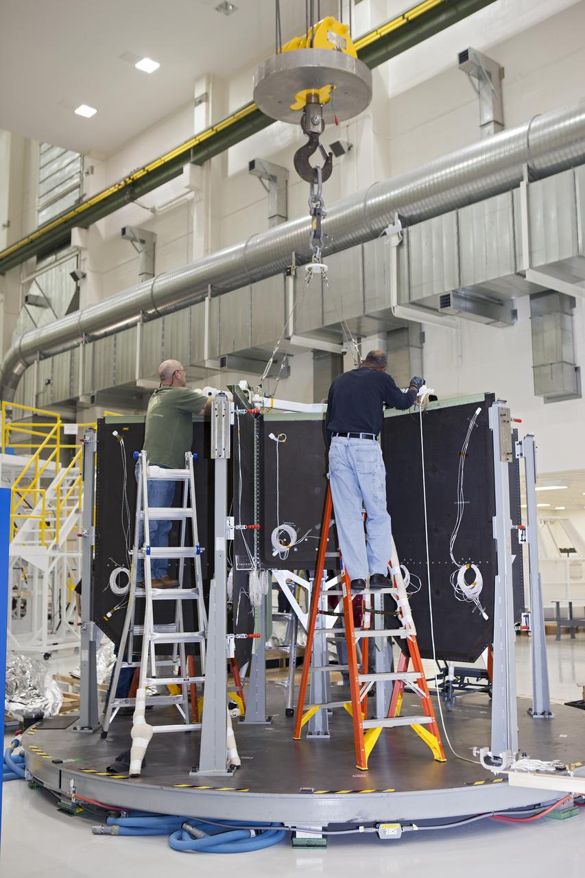 CAPE CANAVERAL, Fla. – Inside the Operations and Checkout Building high bay at NASA’s Kennedy Space Center in Florida, technicians attach a crane to the shear web assembly, or inner core, that will be inserted into the Orion service module. Orion is being prepared for Exploration Flight Test 1, or EFT-1. Orion is the exploration spacecraft designed to carry crews to space beyond low Earth orbit. It will provide emergency abort capability, sustain the crew during the space travel and provide safe re-entry from deep space return velocities. Orion’s first unpiloted test flight is scheduled to launch in 2014 atop a United Launch Alliance Delta IV heavy rocket. A second uncrewed flight test is scheduled for 2017 on the Space Launch System rocket. For more information, visit http:__www.nasa.gov_orion. Photo credit: NASA_Dimitri Gerondidakis