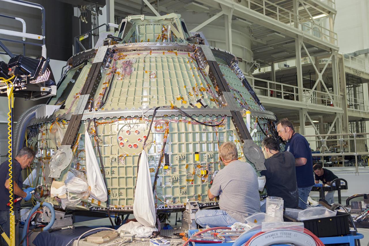 CAPE CANAVERAL, Fla. – Inside the Operations and Checkout Building high bay at NASA’s Kennedy Space Center in Florida, technicians work on the Orion crew module. Orion is being prepared for Exploration Flight Test 1, or EFT-1. Orion is the exploration spacecraft designed to carry crews to space beyond low Earth orbit. It will provide emergency abort capability, sustain the crew during the space travel and provide safe re-entry from deep space return velocities. Orion’s first unpiloted test flight is scheduled to launch in 2014 atop a United Launch Alliance Delta IV heavy rocket. A second uncrewed flight test is scheduled for 2017 on the Space Launch System rocket. For more information, visit http:__www.nasa.gov_orion. Photo credit: NASA_Dimitri Gerondidakis