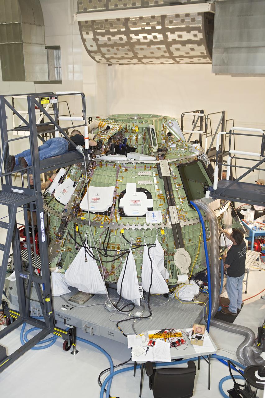 CAPE CANAVERAL, Fla. – Inside the Operations and Checkout Building high bay at NASA’s Kennedy Space Center in Florida, technicians work on the Orion crew module. Orion is being prepared for Exploration Flight Test 1, or EFT-1. Orion is the exploration spacecraft designed to carry crews to space beyond low Earth orbit. It will provide emergency abort capability, sustain the crew during the space travel and provide safe re-entry from deep space return velocities. Orion’s first unpiloted test flight is scheduled to launch in 2014 atop a United Launch Alliance Delta IV heavy rocket. A second uncrewed flight test is scheduled for 2017 on the Space Launch System rocket. For more information, visit http:__www.nasa.gov_orion. Photo credit: NASA_Dimitri Gerondidakis