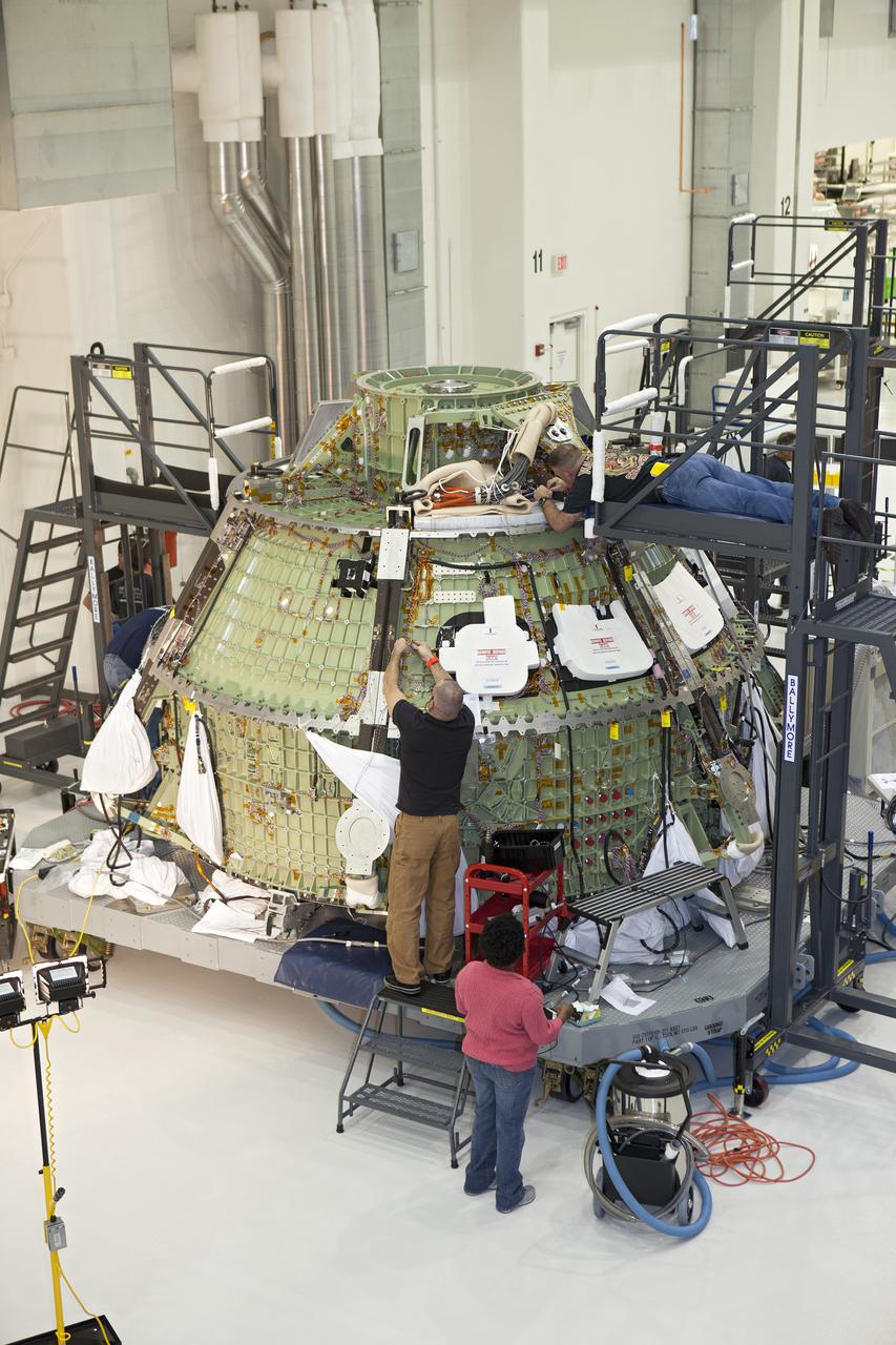 CAPE CANAVERAL, Fla. – Inside the Operations and Checkout Building high bay at NASA’s Kennedy Space Center in Florida, technicians work on the Orion crew module. Orion is being prepared for Exploration Flight Test 1, or EFT-1. Orion is the exploration spacecraft designed to carry crews to space beyond low Earth orbit. It will provide emergency abort capability, sustain the crew during the space travel and provide safe re-entry from deep space return velocities. Orion’s first unpiloted test flight is scheduled to launch in 2014 atop a United Launch Alliance Delta IV heavy rocket. A second uncrewed flight test is scheduled for 2017 on the Space Launch System rocket. For more information, visit http:__www.nasa.gov_orion. Photo credit: NASA_Dimitri Gerondidakis