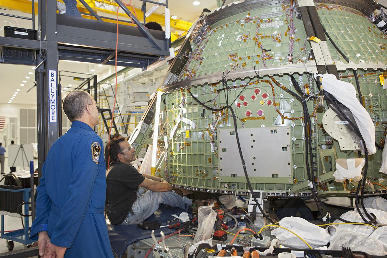 CAPE CANAVERAL, Fla. – Inside the Operations and Checkout Building high bay at NASA’s Kennedy Space Center in Florida, astronaut Don Pettit watches as a technician works on the Orion crew module. Orion is being prepared for Exploration Flight Test 1, or EFT-1. Orion is the exploration spacecraft designed to carry crews to space beyond low Earth orbit. It will provide emergency abort capability, sustain the crew during the space travel and provide safe re-entry from deep space return velocities. Orion’s first unpiloted test flight is scheduled to launch in 2014 atop a United Launch Alliance Delta IV heavy rocket. A second uncrewed flight test is scheduled for 2017 on the Space Launch System rocket. For more information, visit http:__www.nasa.gov_orion. Photo credit: NASA_Dimitri Gerondidakis