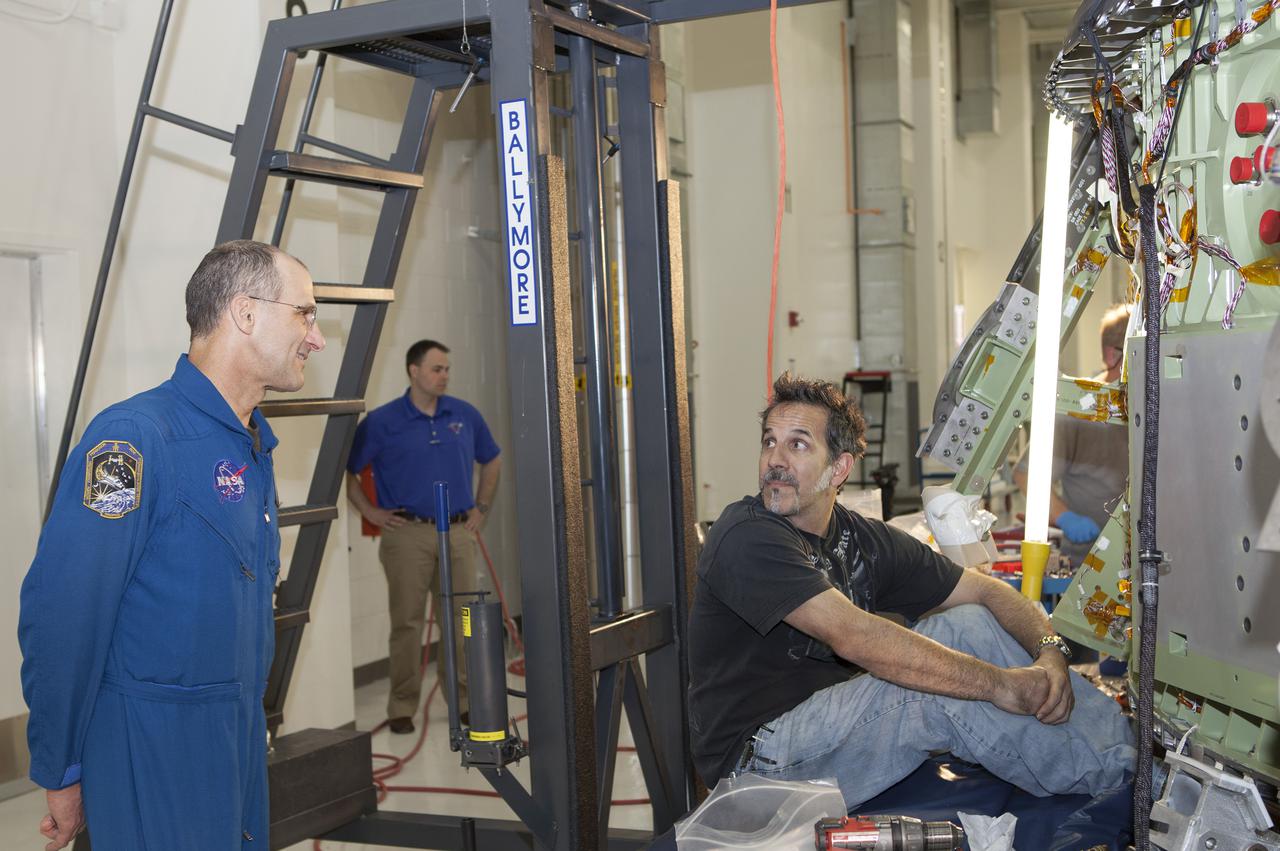 CAPE CANAVERAL, Fla. – Inside the Operations and Checkout Building high bay at NASA’s Kennedy Space Center in Florida, astronaut Don Pettit speaks with a technician who is working on the Orion crew module. Orion is being prepared for Exploration Flight Test 1, or EFT-1. Orion is the exploration spacecraft designed to carry crews to space beyond low Earth orbit. It will provide emergency abort capability, sustain the crew during the space travel and provide safe re-entry from deep space return velocities. Orion’s first unpiloted test flight is scheduled to launch in 2014 atop a United Launch Alliance Delta IV heavy rocket. A second uncrewed flight test is scheduled for 2017 on the Space Launch System rocket. For more information, visit http:__www.nasa.gov_orion. Photo credit: NASA_Dimitri Gerondidakis