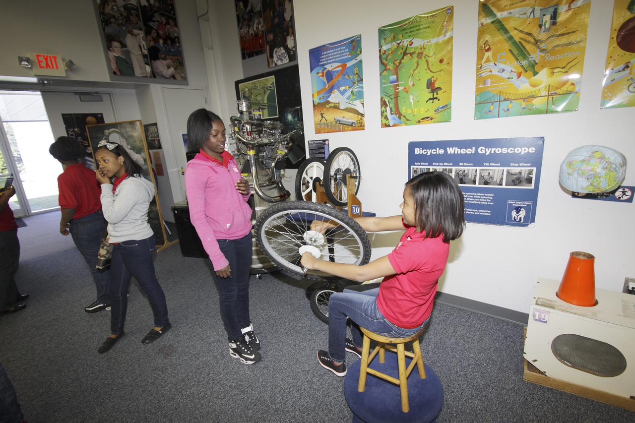 CAPE CANAVERAL, Fla. – Middle and High school students from Florida's Putnam and Volusia counties use a bicycle wheel as a gyroscope to simulate principals of motion during a science demonstration at the NASA's Center for Space Education at the Kennedy Space Center.   The 11 to 18-year-old students are part of Delta Academy and Delta GEMS, an African American women’s mentoring program affiliated with Delta Sigma Theta. The sorority uses their collective efforts to promote academic excellence, provide scholarships and support underserved students. As a part of the science program, the young scholars participated in a presentation by professional women who work at Kennedy discussing career choices and encouraging interest in science, technology, engineering and mathematics STEM careers. Photo credit: NASA_Jim Grossmann