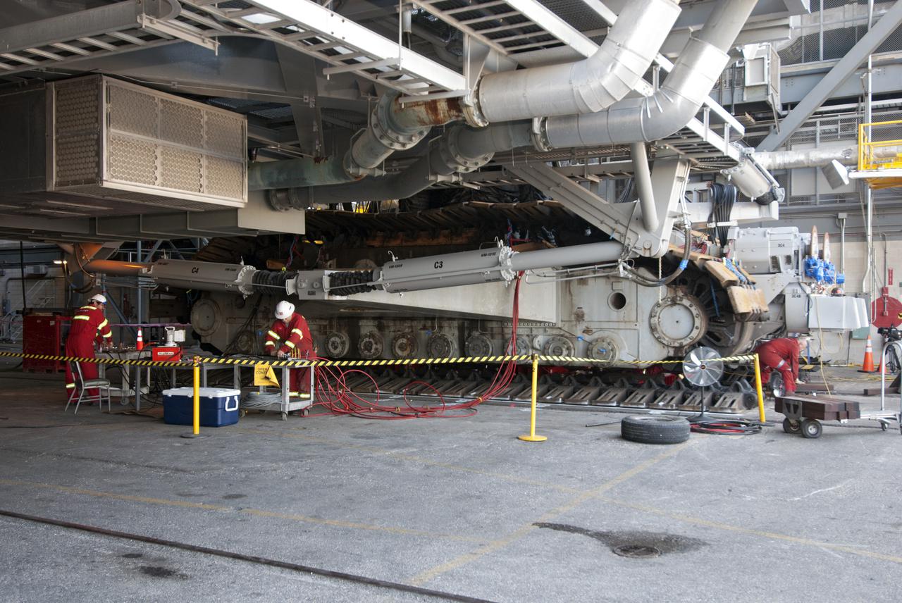 CAPE CANAVERAL, Fla. -- Technicians in the Vehicle Assembly Building at NASA’s Kennedy Space Center in Florida, prepare crawler-transporter 2, or CT-2, for removal of the roller bearing assemblies. After inspections, new assemblies will be installed. The Ground Systems Development and Operations Program office at Kennedy is overseeing the upgrades to CT-2 so that it can carry NASA’s Space Launch System heavy-lift rocket and new Orion spacecraft to the launch pad. For more than 45 years the crawler-transporters were used to transport the mobile launcher platform and the Apollo-Saturn V rockets and, later, space shuttles to Launch Pads 39A and B. For more information: http:__www.nasa.gov_exploration_systems_ground_crawler-transporter_bearings.html Photo credit: NASA_Tim Jacobs