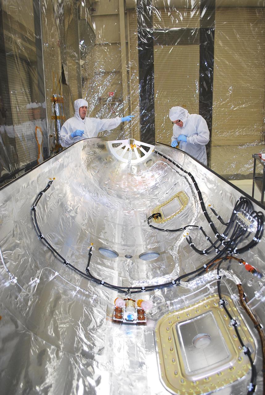 VANDENBERG AIR FORCE BASE, Calif. -- Technicians inside Building 1555 conduct inspection, cleaning and electrical testing on half of a payload fairing for the Orbital Sciences Corp. Pegasus XL rocket that will launch the Interface Region Imaging Spectrograph, or IRIS, spacecraft. The fairing will be fitted to the nose of the Pegasus to protect the spacecraft from atmospheric heating and stress during launch.    IRIS will open a new window of discovery by tracing the flow of energy and plasma through the chromospheres and transition region into the sun’s corona using spectrometry and imaging. IRIS fills a crucial gap in our ability to advance studies of the sun-to-Earth connection by tracing the flow of energy and plasma through the foundation of the corona and the region around the sun known as the heliosphere.  Photo credit: VAFB_Randy Beaudoin