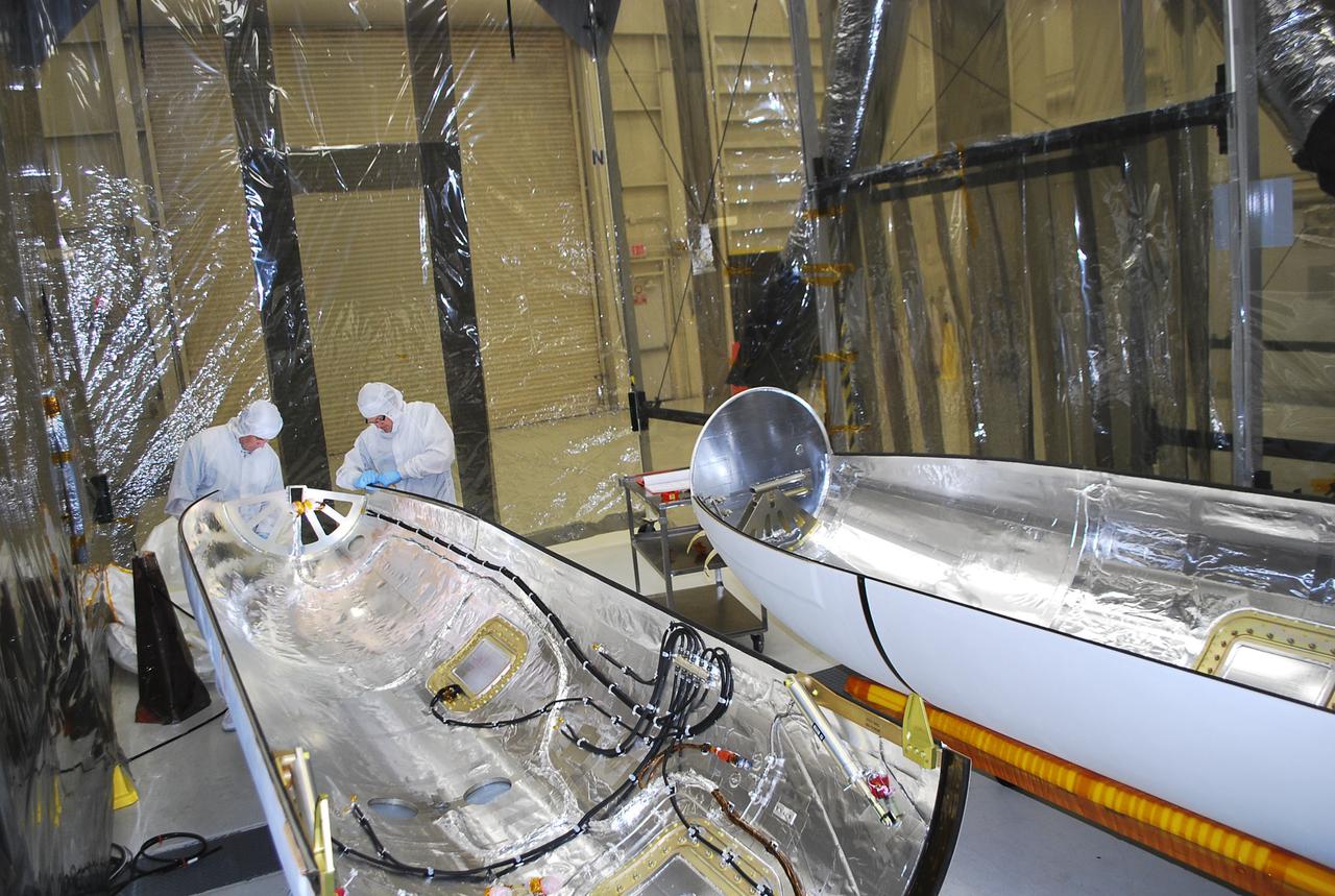 VANDENBERG AIR FORCE BASE, Calif. -- Technicians inside Building 1555 conduct inspection, cleaning and electrical testing on half of a payload fairing for the Orbital Sciences Corp. Pegasus XL rocket that will launch the Interface Region Imaging Spectrograph, or IRIS, spacecraft. The fairing will be fitted to the nose of the Pegasus to protect the spacecraft from atmospheric heating and stress during launch.    IRIS will open a new window of discovery by tracing the flow of energy and plasma through the chromospheres and transition region into the sun’s corona using spectrometry and imaging. IRIS fills a crucial gap in our ability to advance studies of the sun-to-Earth connection by tracing the flow of energy and plasma through the foundation of the corona and the region around the sun known as the heliosphere.  Photo credit: VAFB_Randy Beaudoin