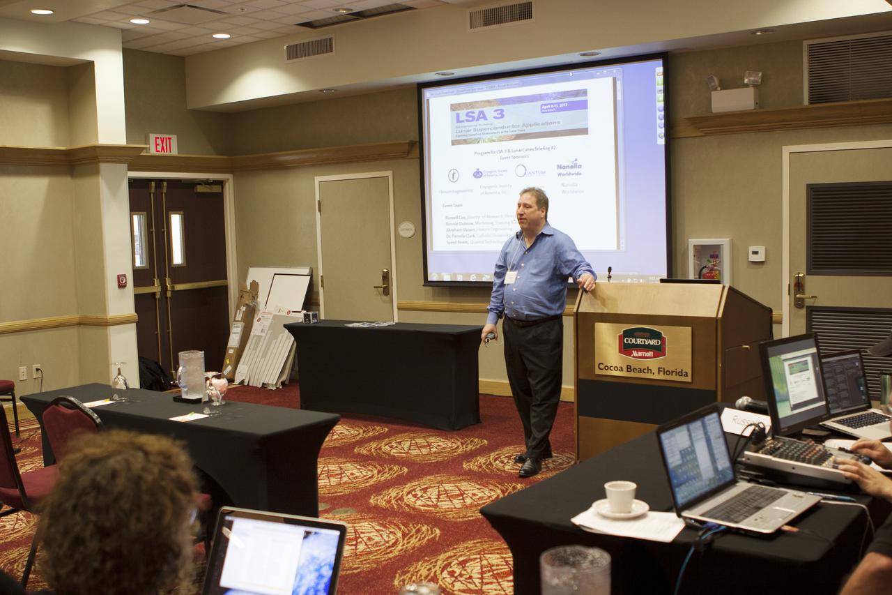 CAPE CANAVERAL, Fla. – At the Courtyard by Marriott hotel in Cocoa Beach, Fla., Russell Cox, director of research with Flexure Engineering, welcomes participants in the room and those participating online to the Third International Workshop on Lunar Superconductor Applications. The workshop included presentations from several engineers and researchers at Kennedy Space Center.  The three-day workshop included presentations from speakers throughout the country and focused on Lunar in-situ resource utilization, NASA’s Lunar Ice Prospector called RESOLVE, CubeSats, cryogenic storage and many other topics related to lunar exploration. Photo credit: NASA_Jim Grossmann