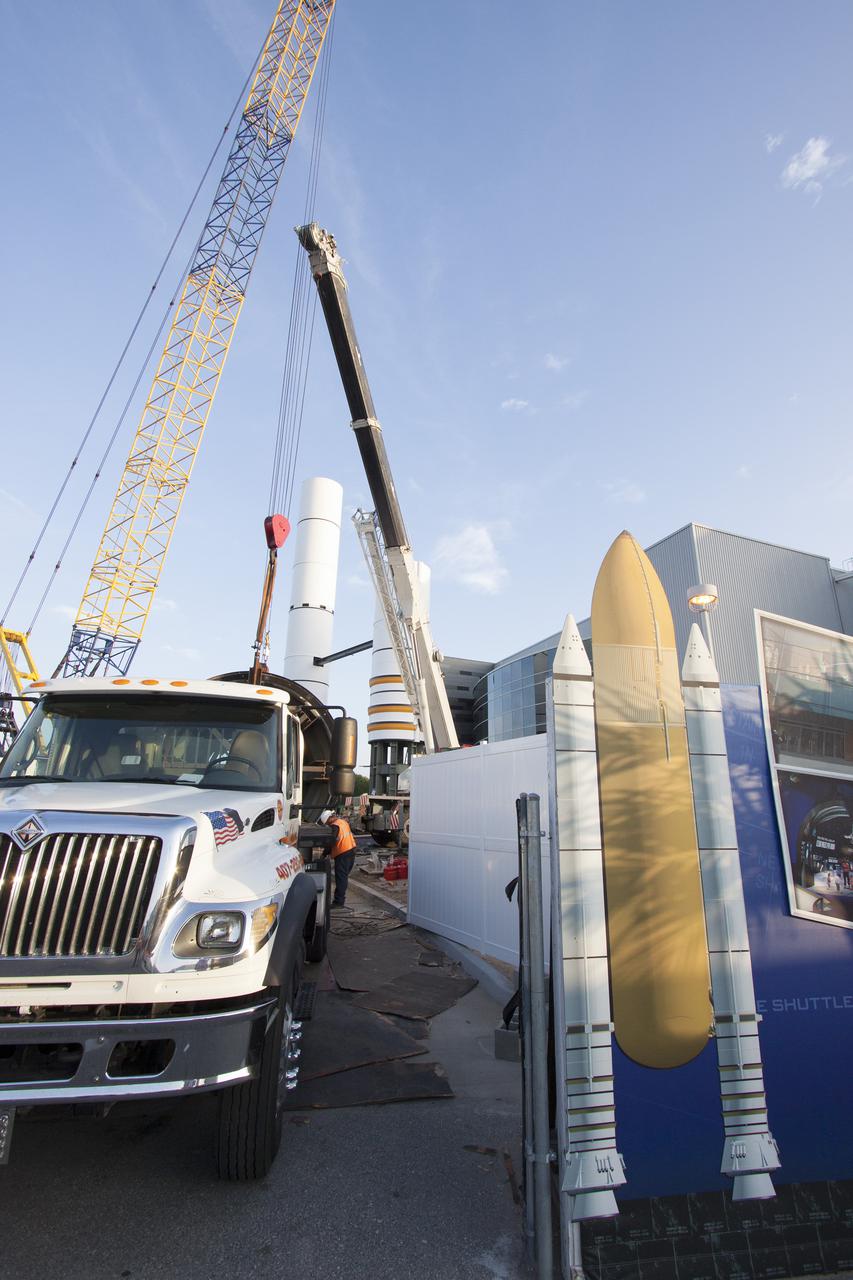 CAPE CANAVERAL, Fla. – Workers prepare to lift a segment for a set of twin, full-size replica Solid Rocket Boosters SRBs in front of the Space Shuttle Atlantis exhibit under construction at the Kennedy Space Center Visitor Complex in Florida. Atlantis is housed in the building behind the SRB stack. An external tank replica will be added later to the middle of the SRBs to complete the display. The SRBs stand 150 feet tall, while the external tank will reach 184 feet when it is finished. The shuttle was mounted to the stack and depended on the power of the SRBs to lift it off the launch pad and start it on its way to space. The external tank was loaded with liquid propellants for the shuttle's three main engines. Photo credit: NASA_Jim Grossmann